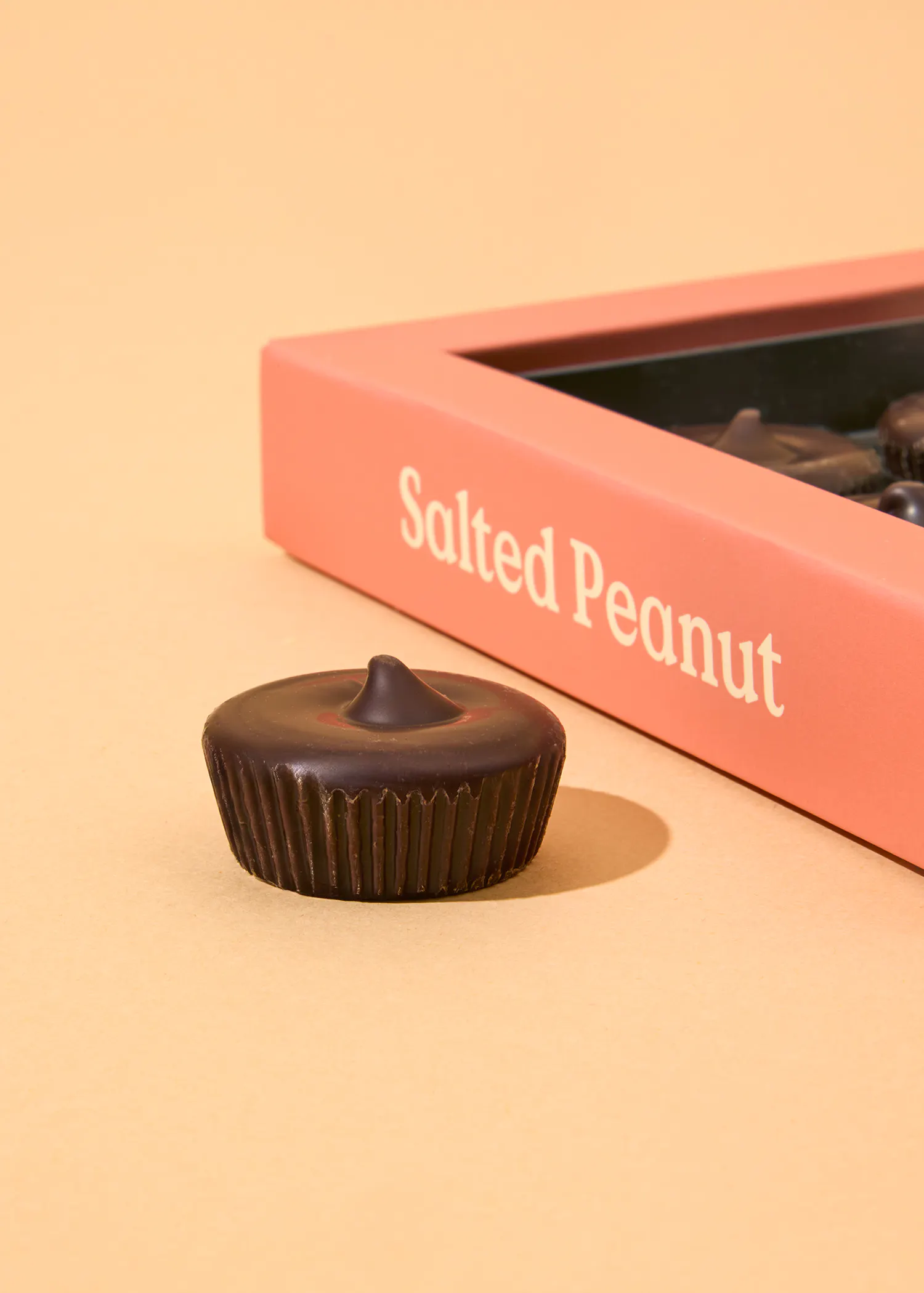 une boîte de cacahuètes salées se trouve à côté d' une tasse de chocolat