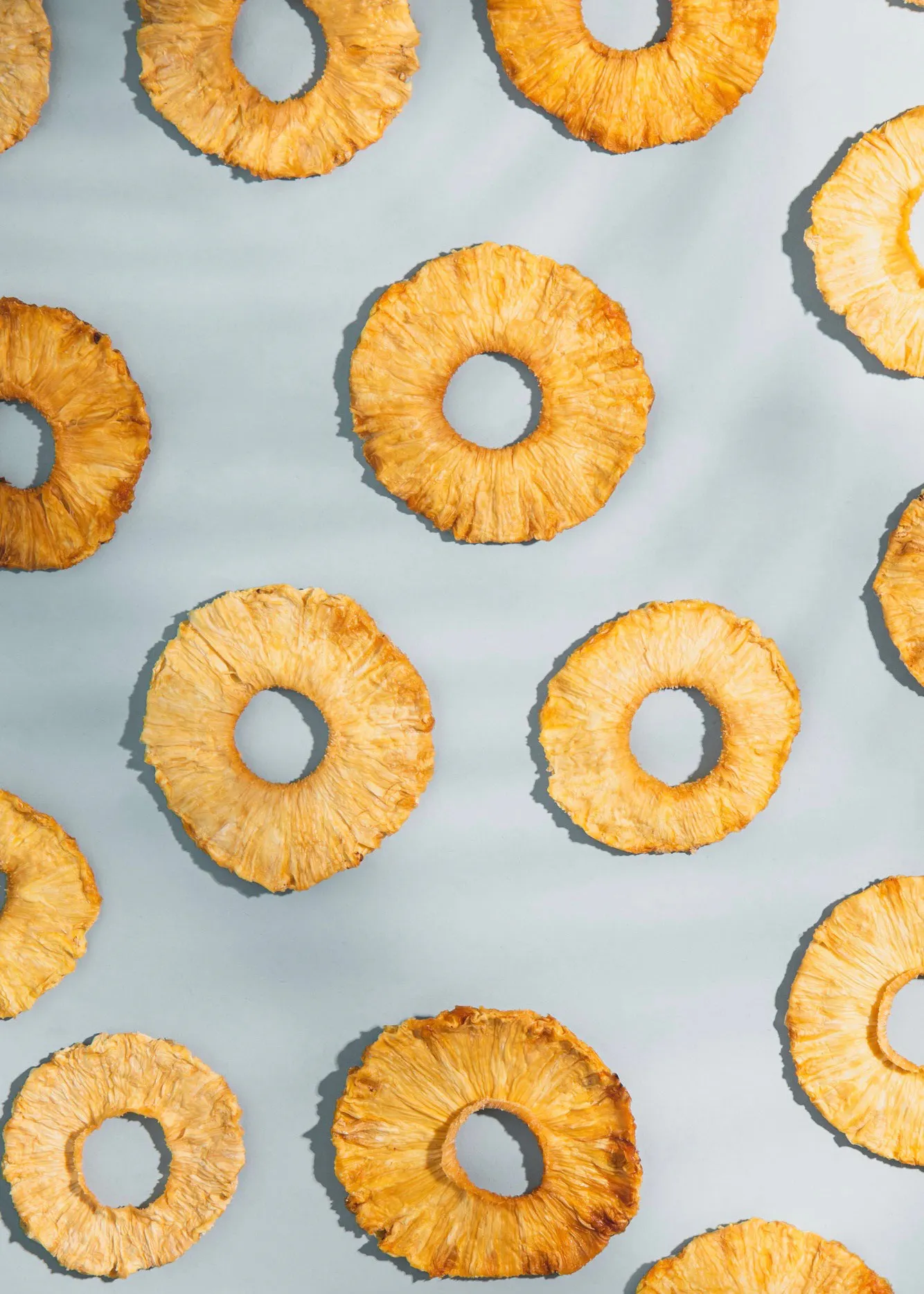 ein nahtloses Muster aus getrockneten Ananasringe auf einem blauen Hintergrund