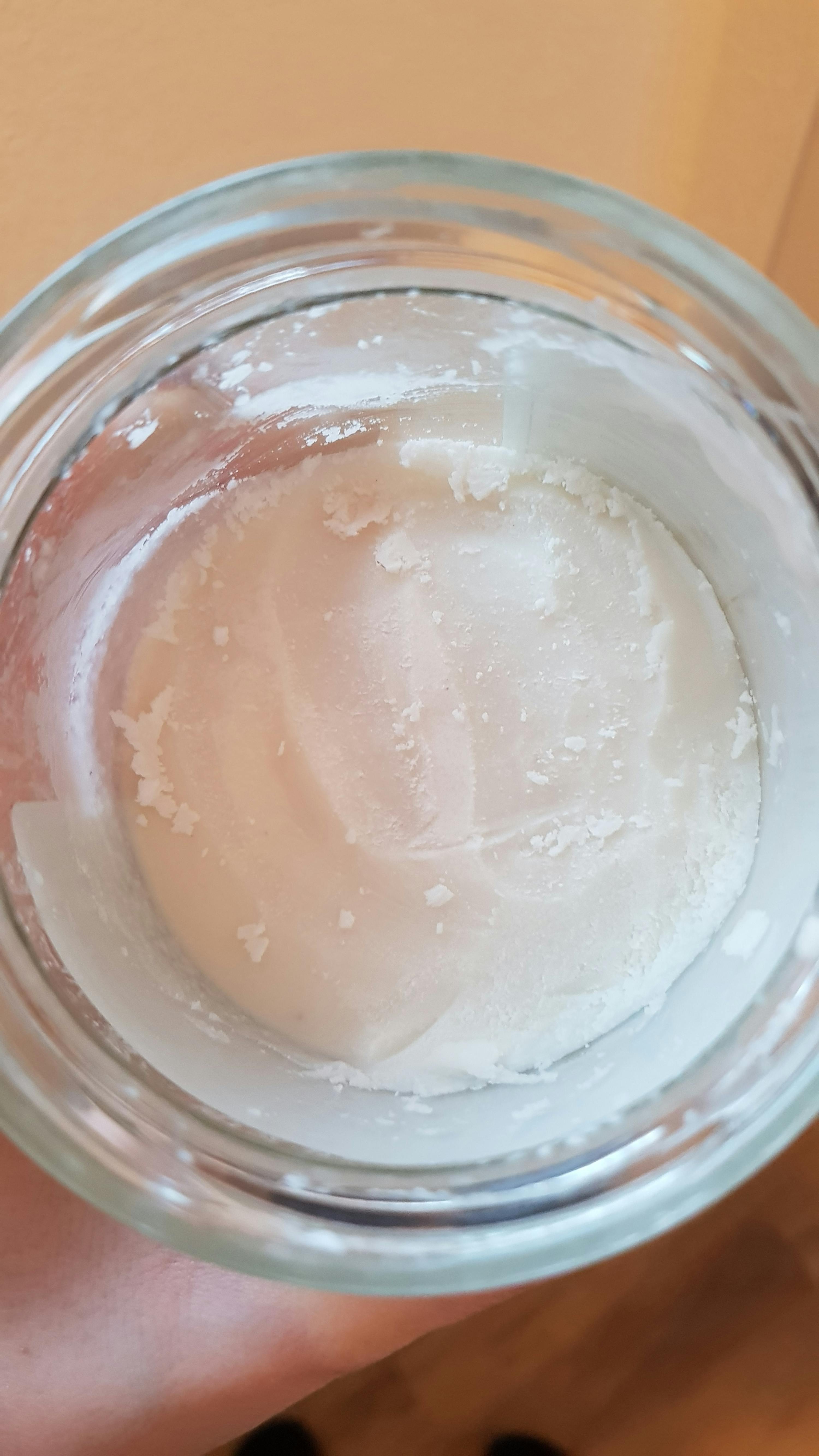 a close up of a jar of white liquid
