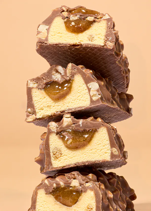 eine Reihe von Schokoladenriegeln mit Eis darauf gestapelt