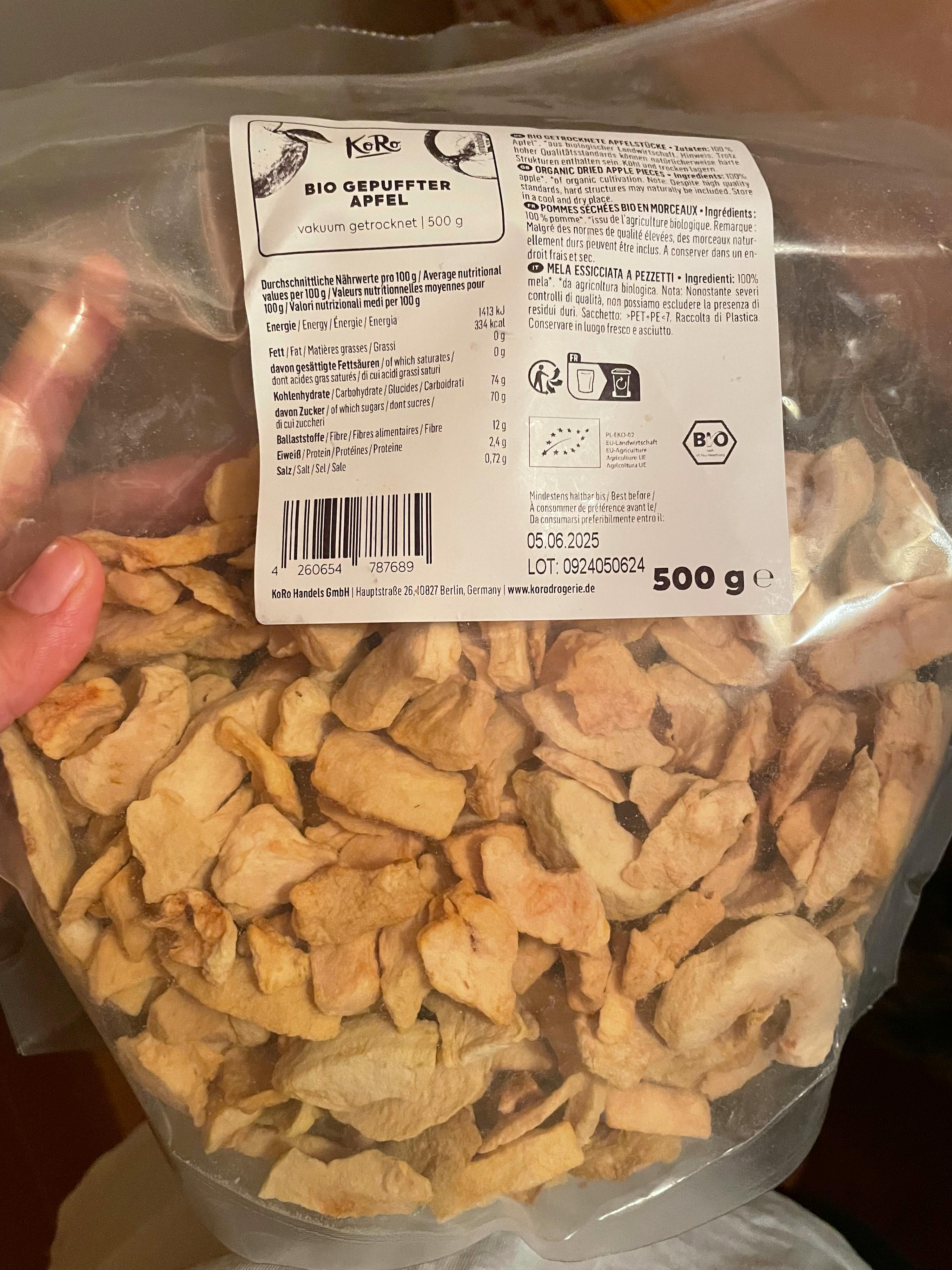 a person is holding a bag of dried apple slices