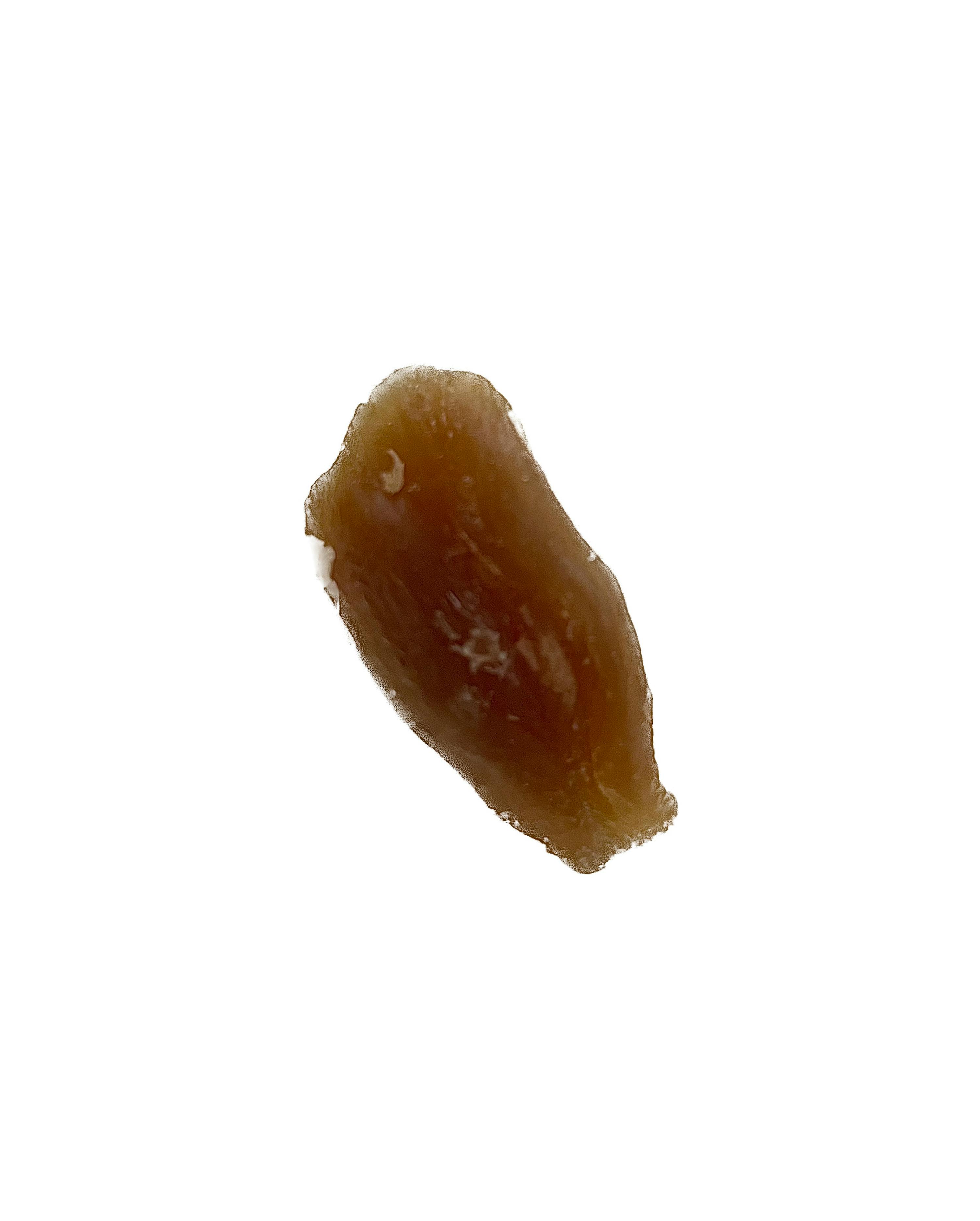 a close up of a piece of brown substance on a white background