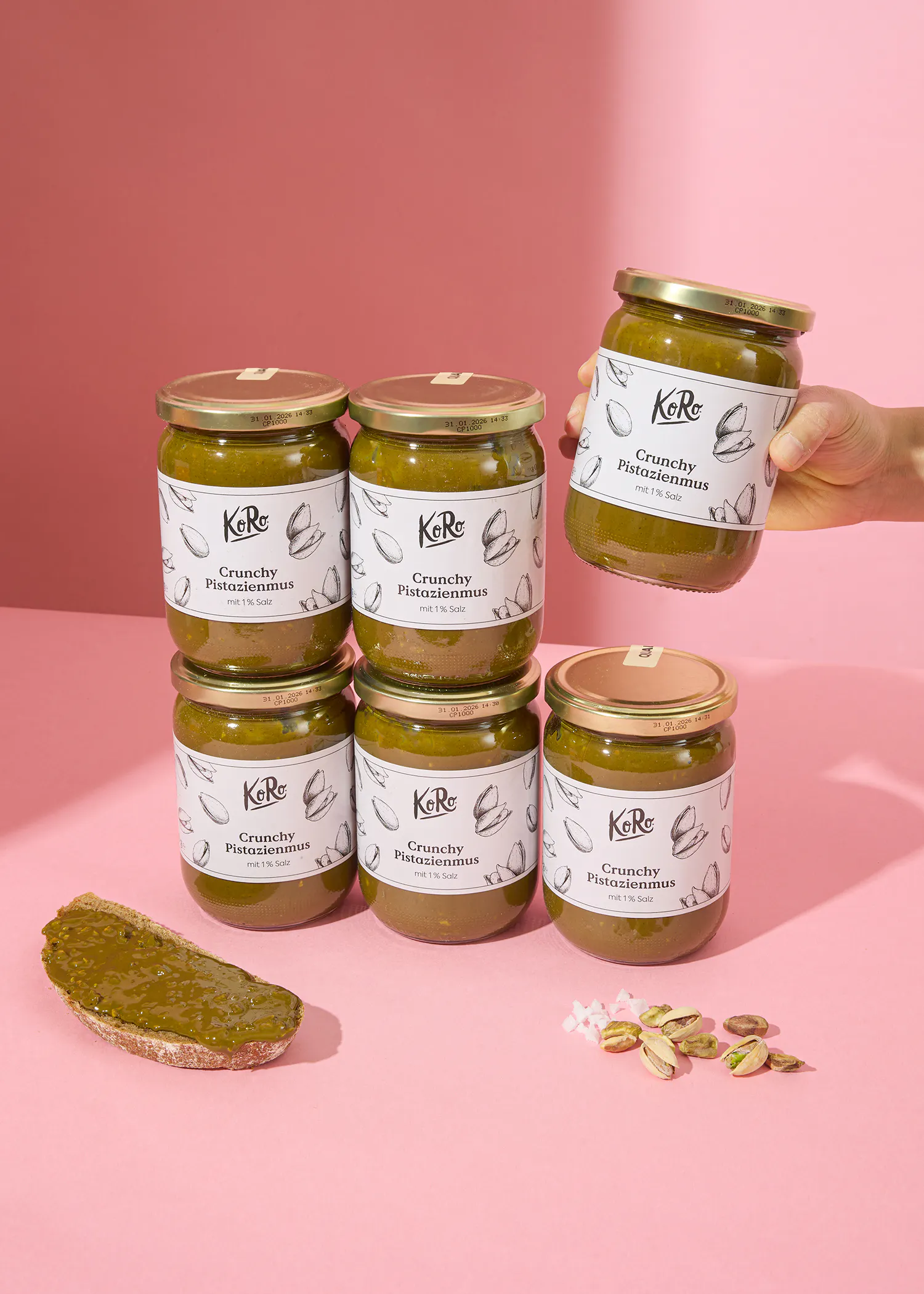 una persona sostiene seis frascos de salsa de pistachos crujientes