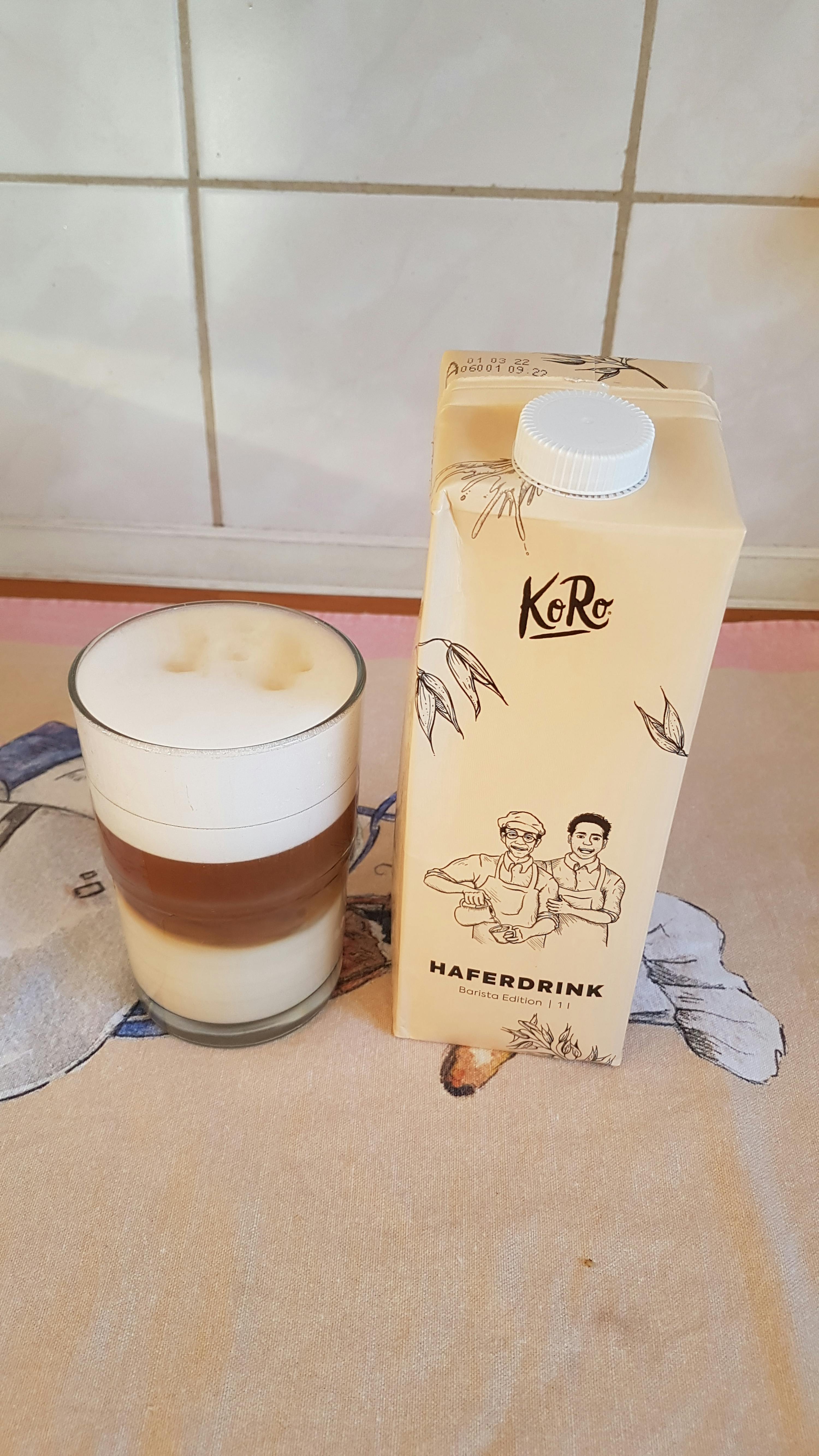 une bouteille de boisson d' avoine est assise à côté d' un verre de boisson d' avoine