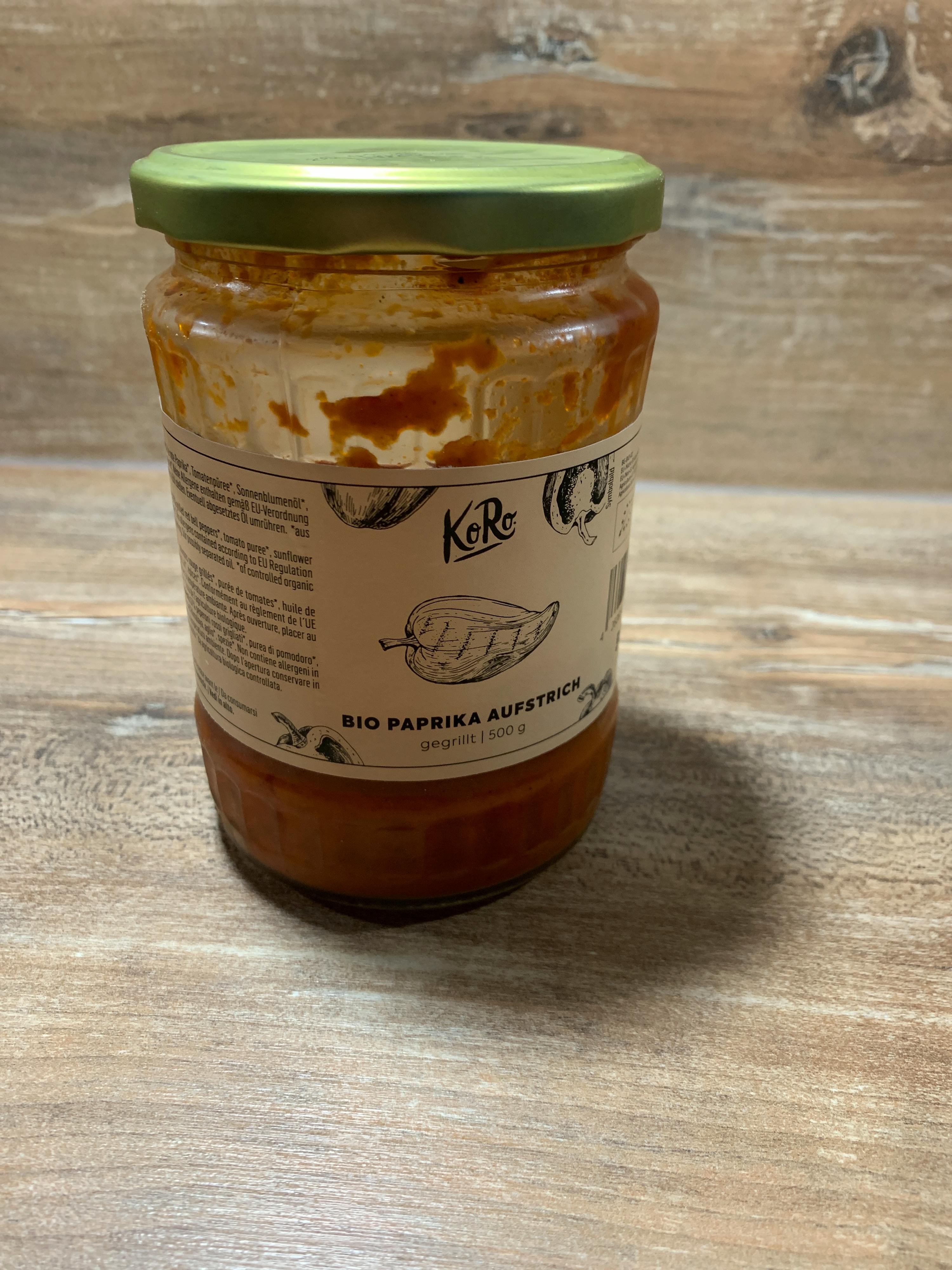 ein Glas mit einem grünen Deckel steht auf einem Holztisch