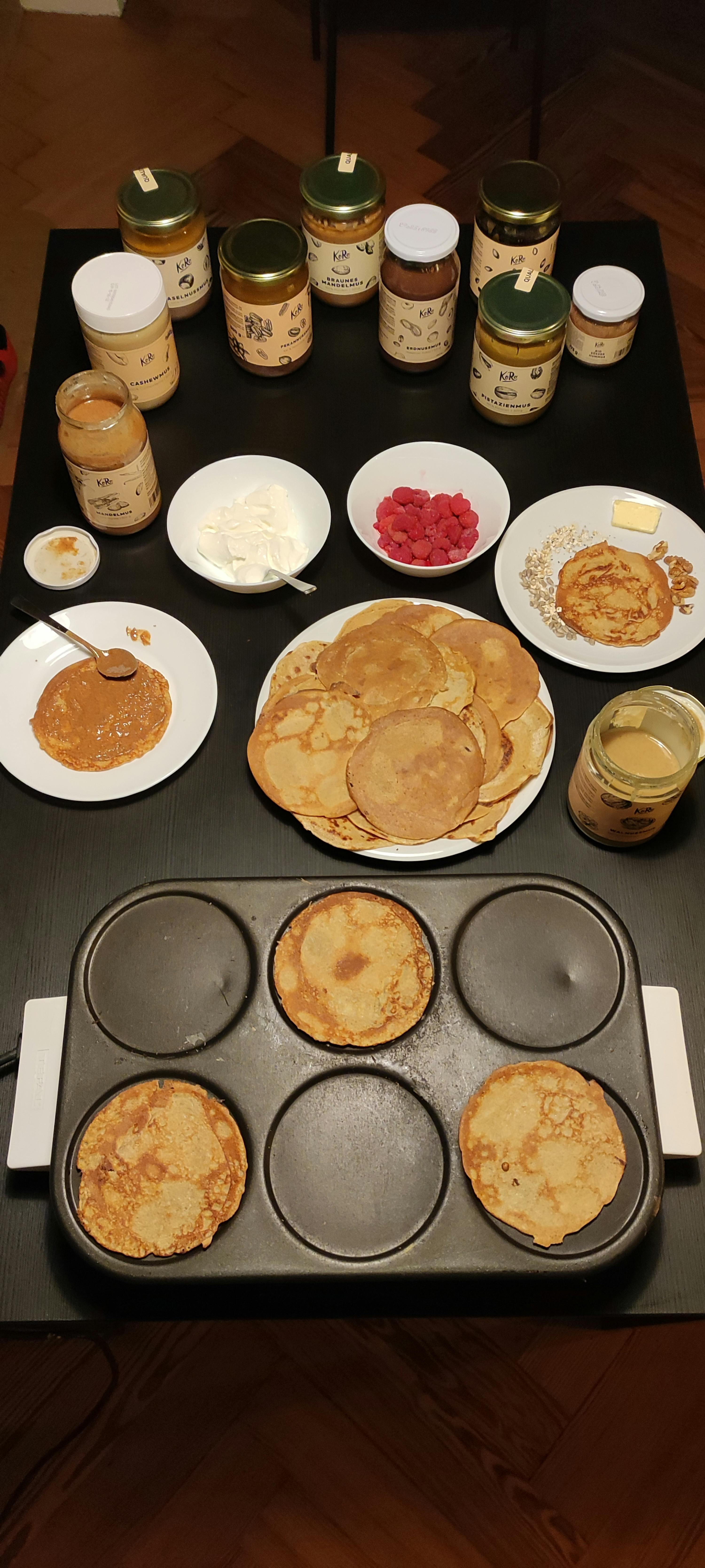 une table avec des plaques de crêpes et des bocaux de beurre de cacahuète