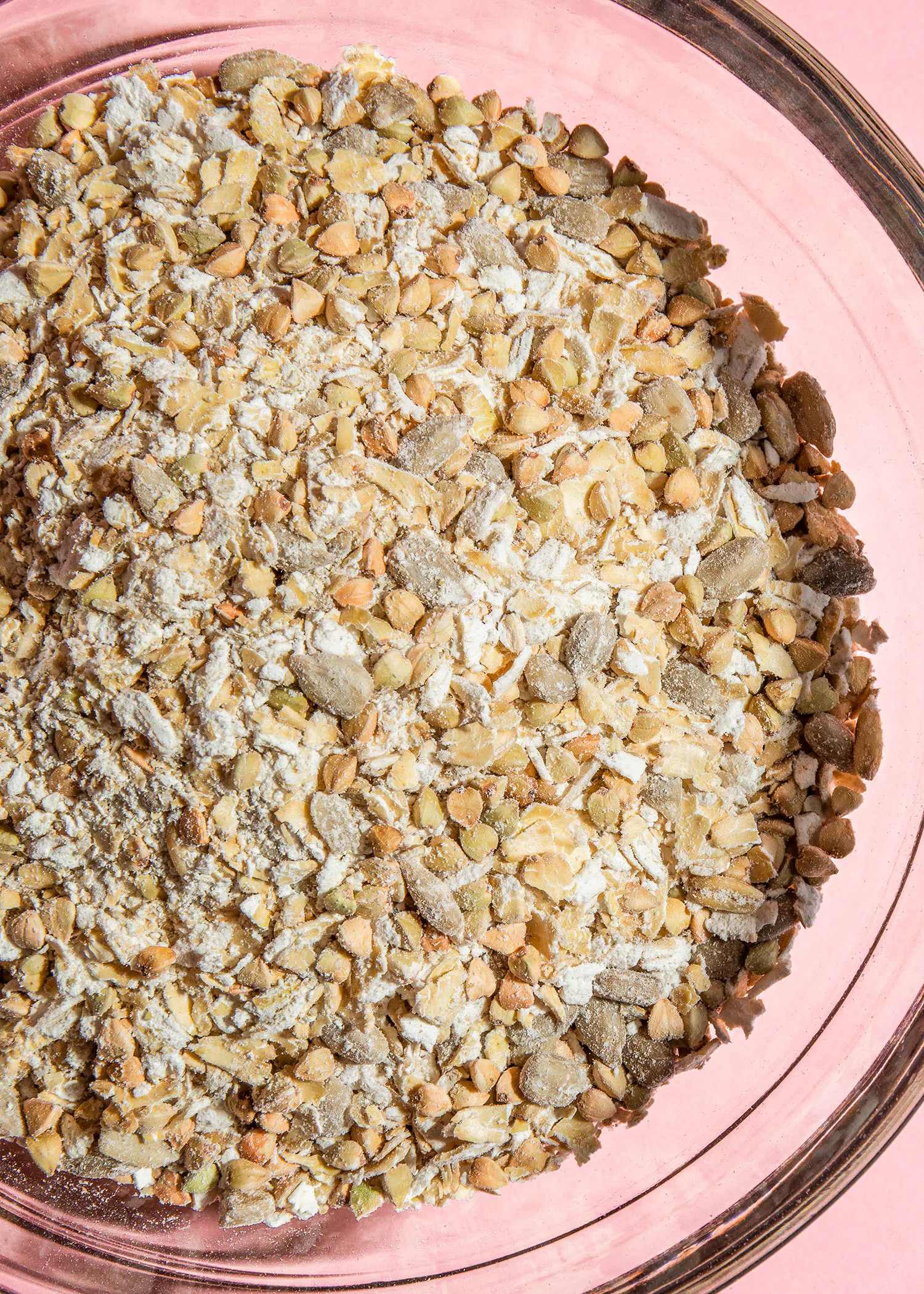 a glass bowl filled with a variety of grains and seeds