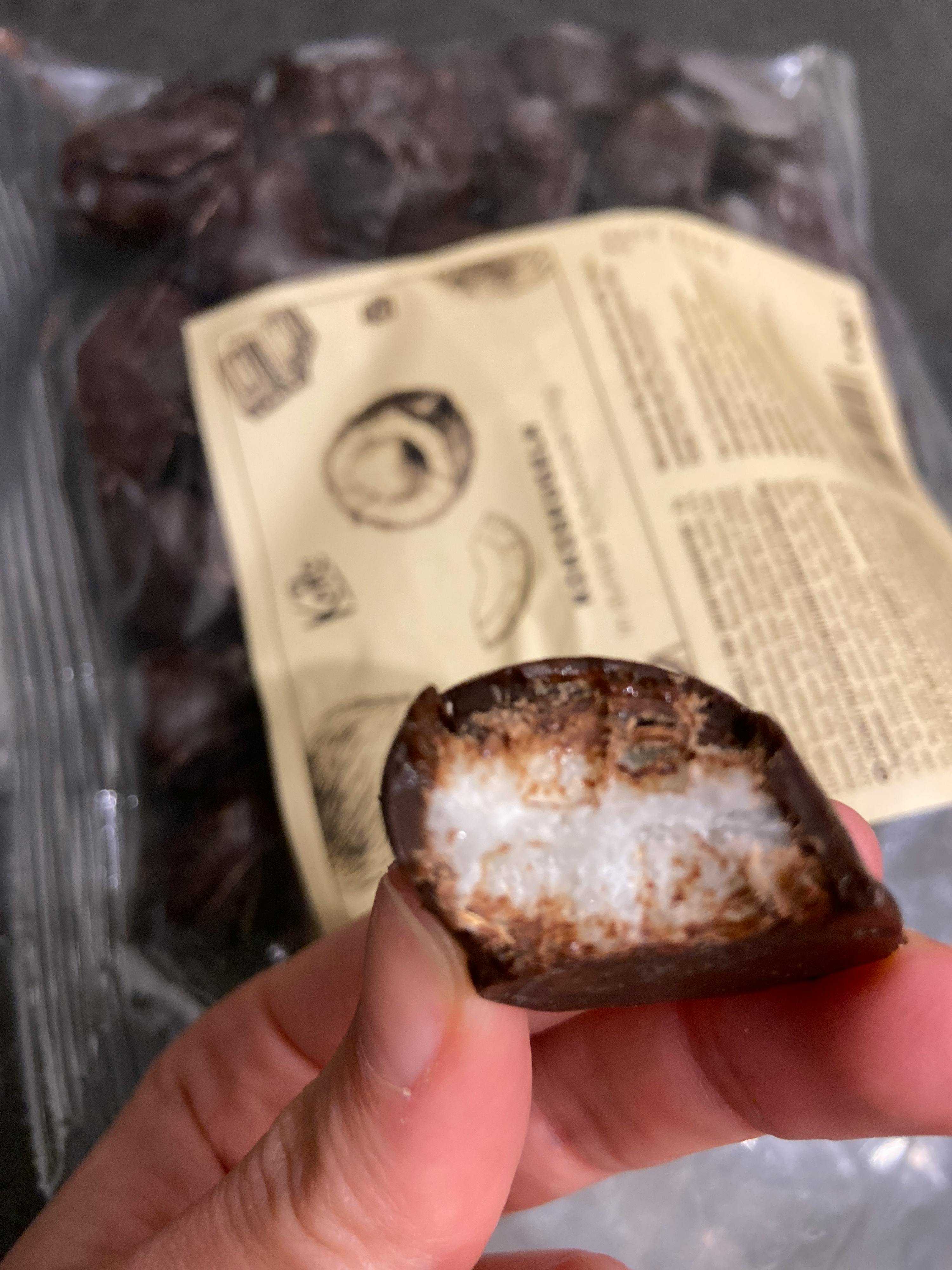 a person is holding a piece of chocolate with a label that says ' kd ' on it