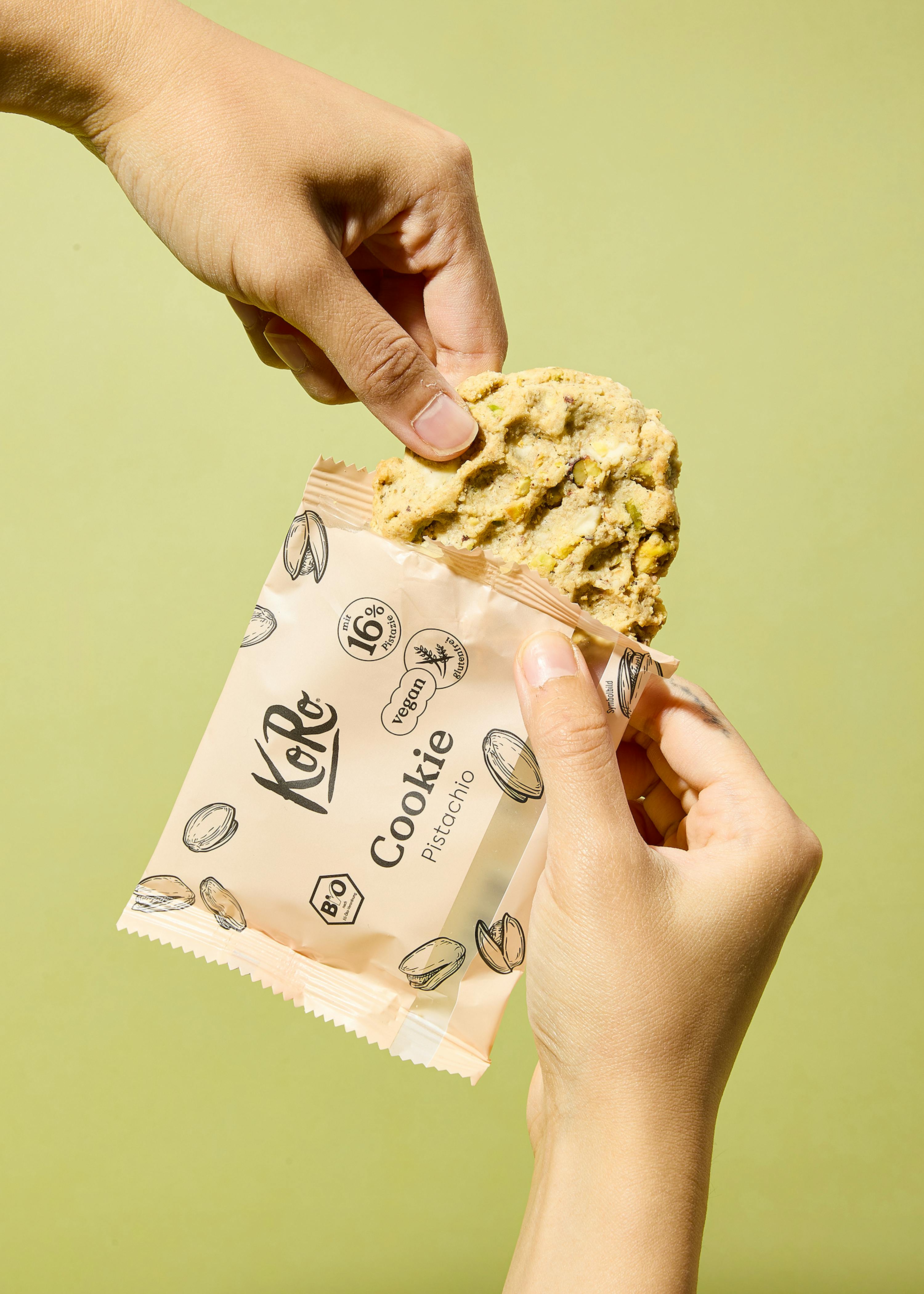 une personne tient un cookie de pistache dans sa main