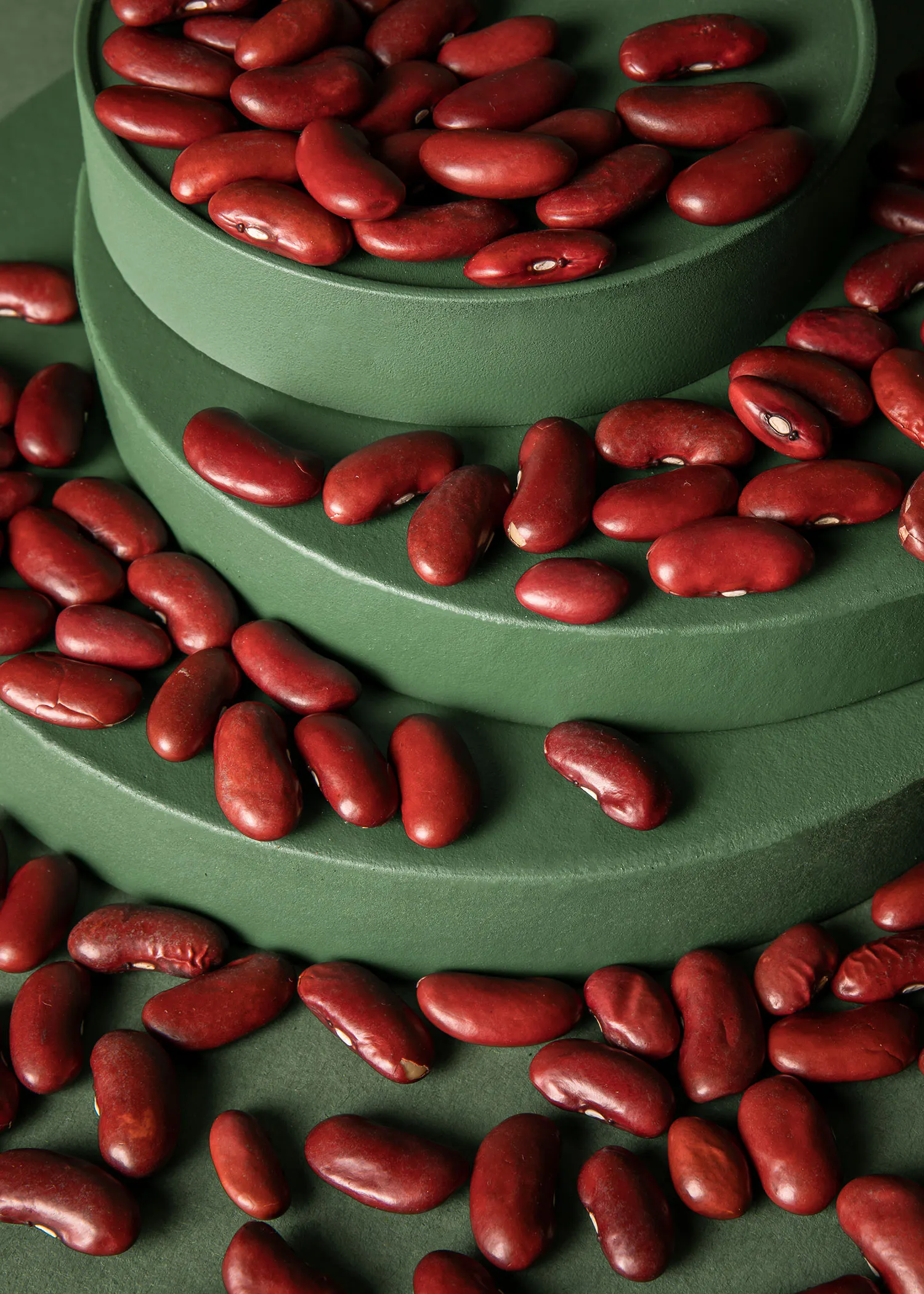 un tas de haricots rouges est empilé sur des étagères vertes