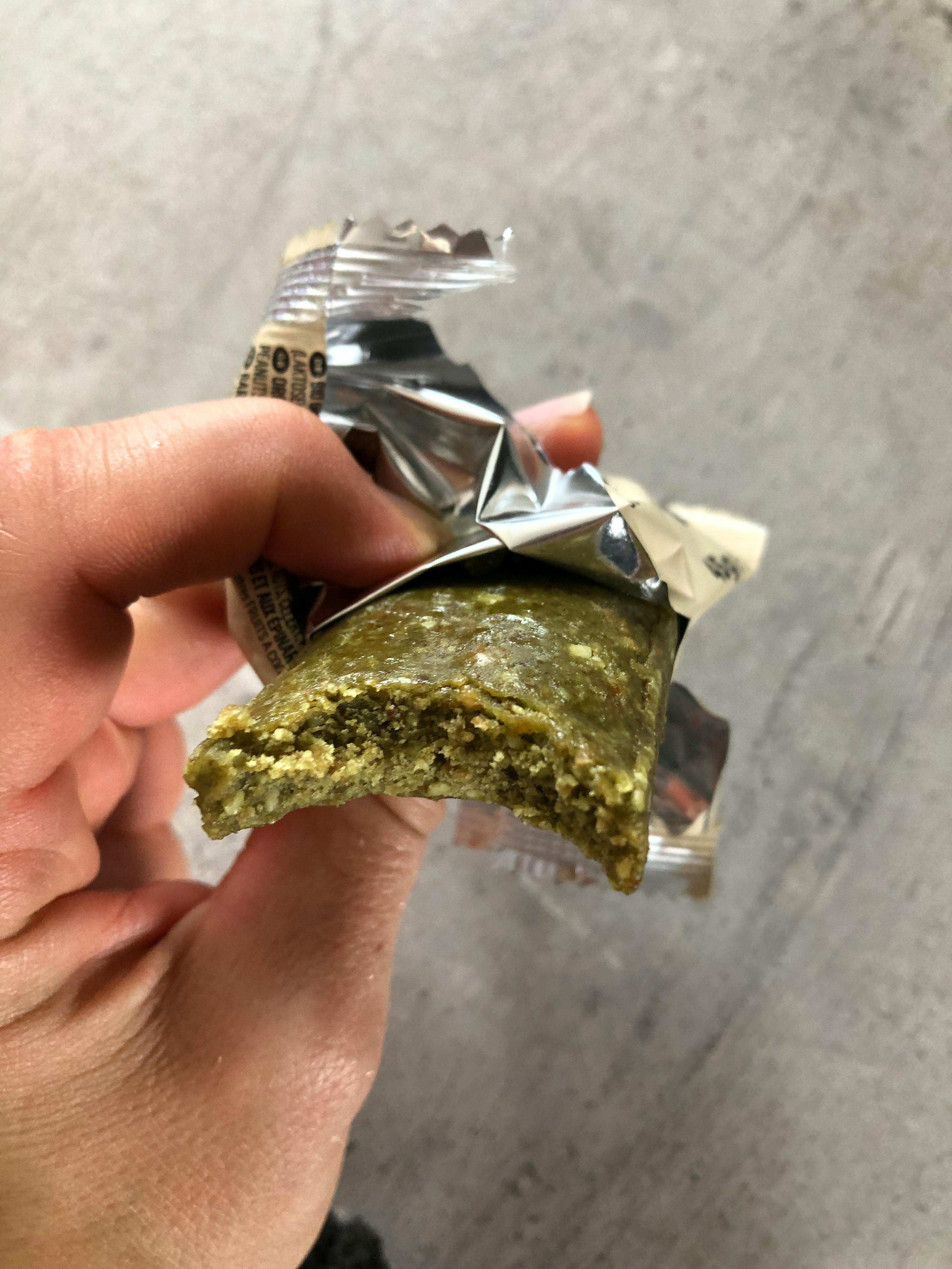 a person is holding a piece of food that has a bite taken out of it