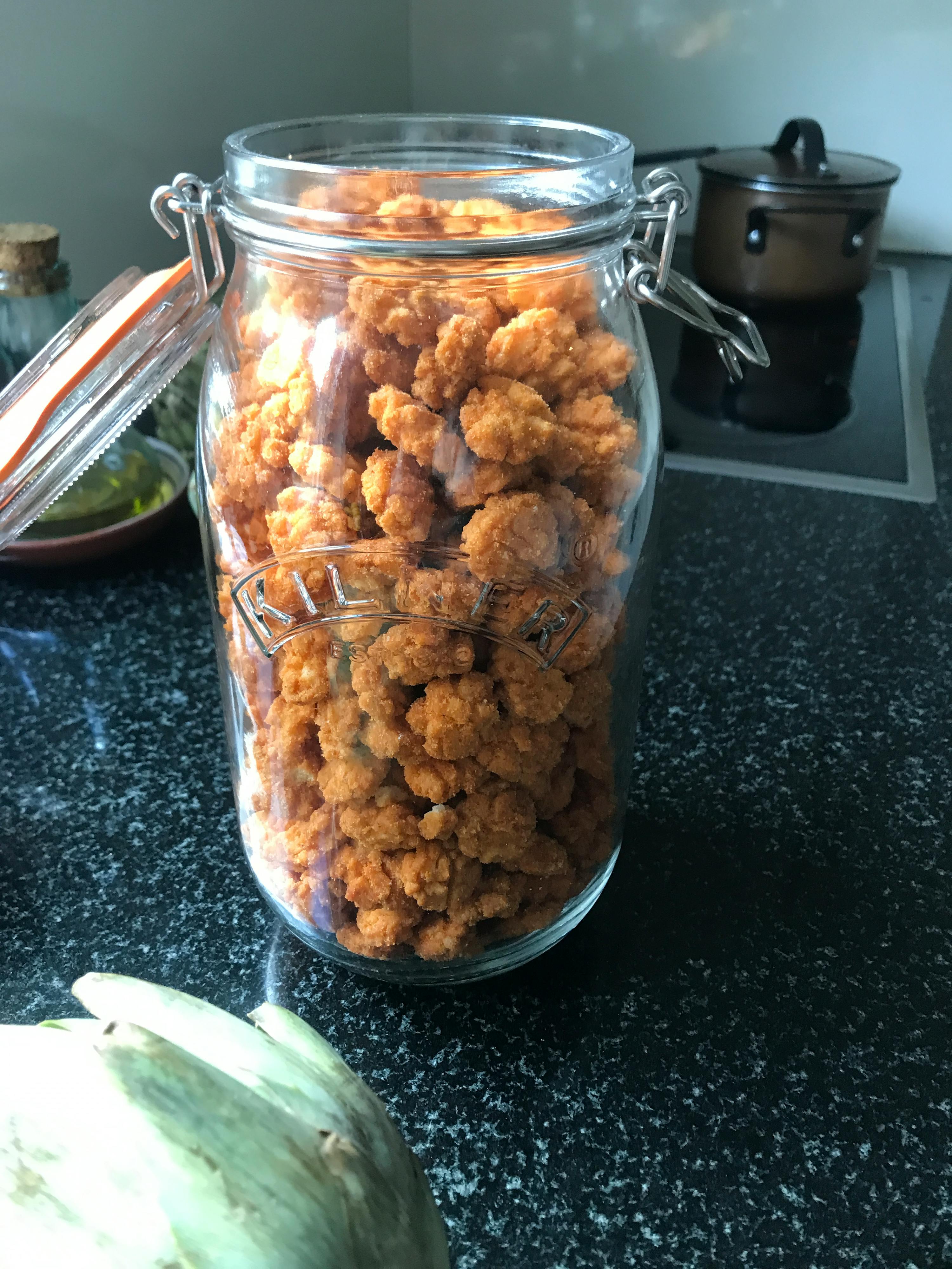 un bocal en verre rempli de nourriture est sur une table