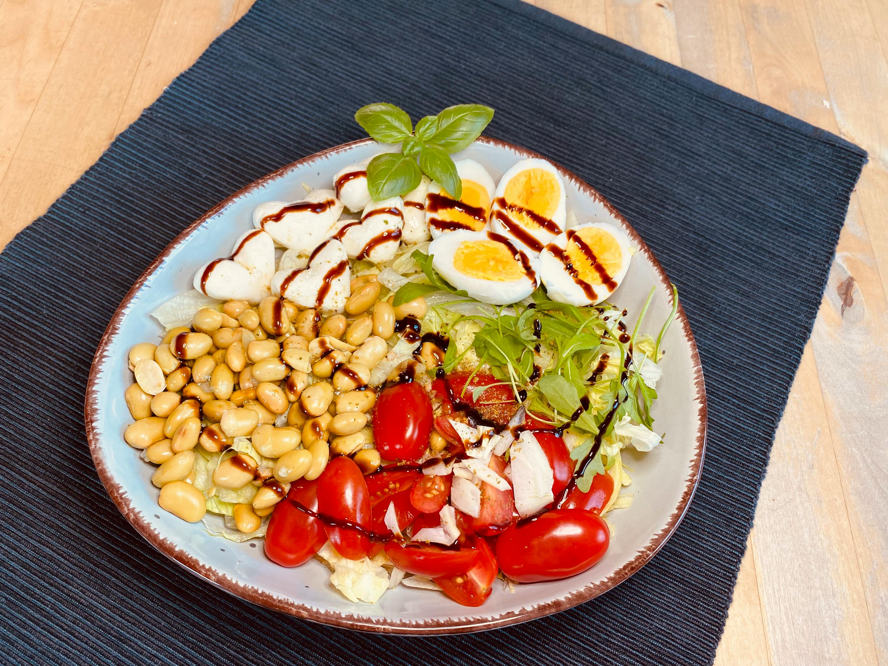 ein Salat mit Bohnen , Tomaten , Eiern und Mozzarella