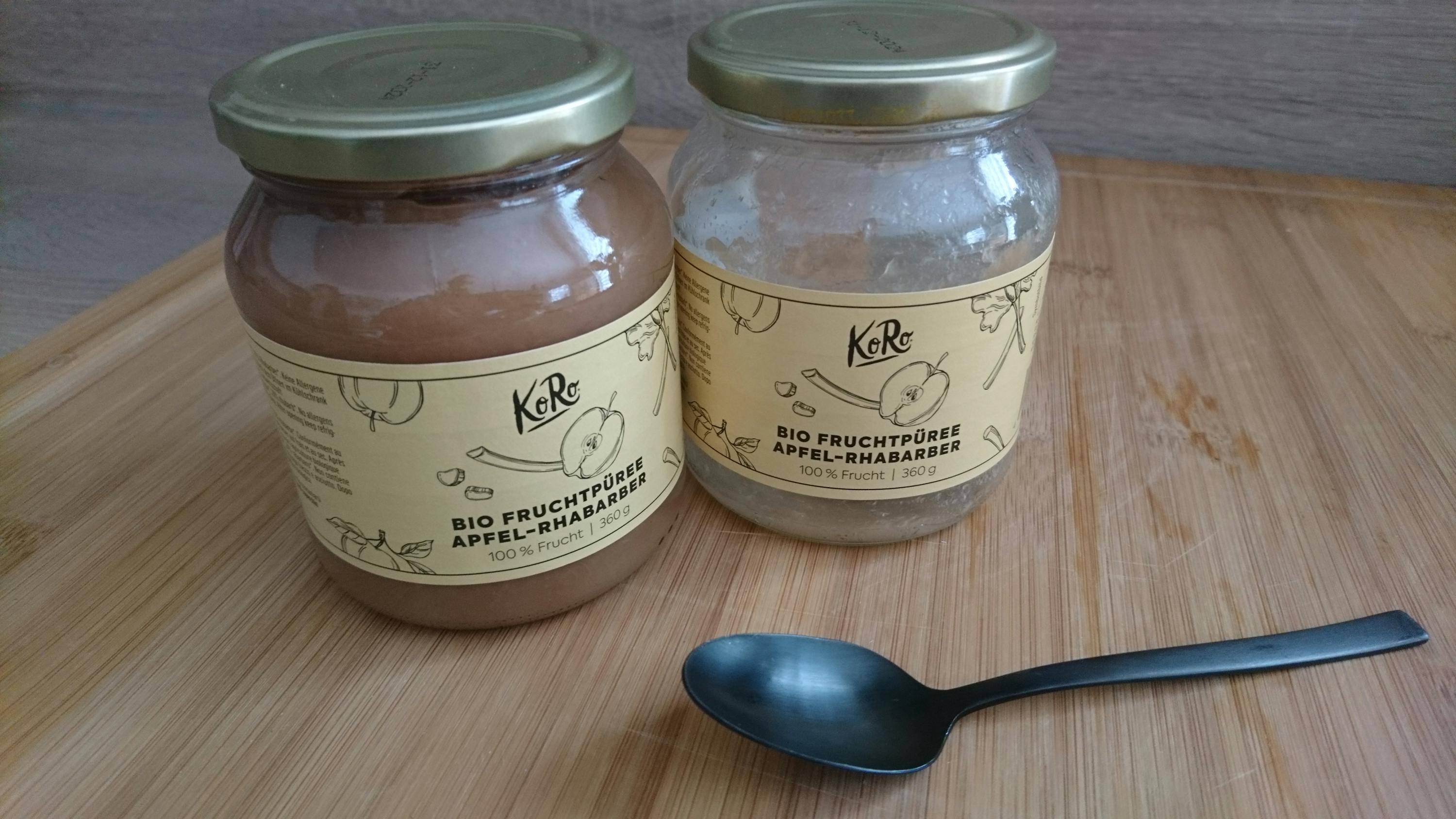 deux bocaux de compote de pomme sur une table en bois