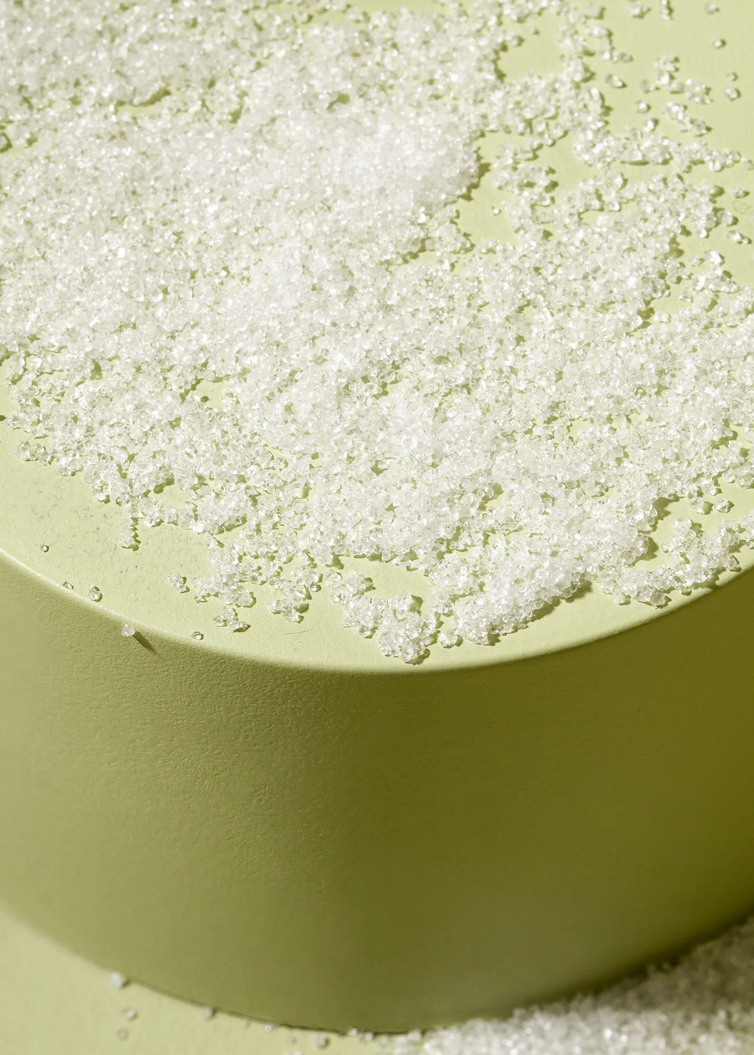 a green surface with a pile of white sugar on it