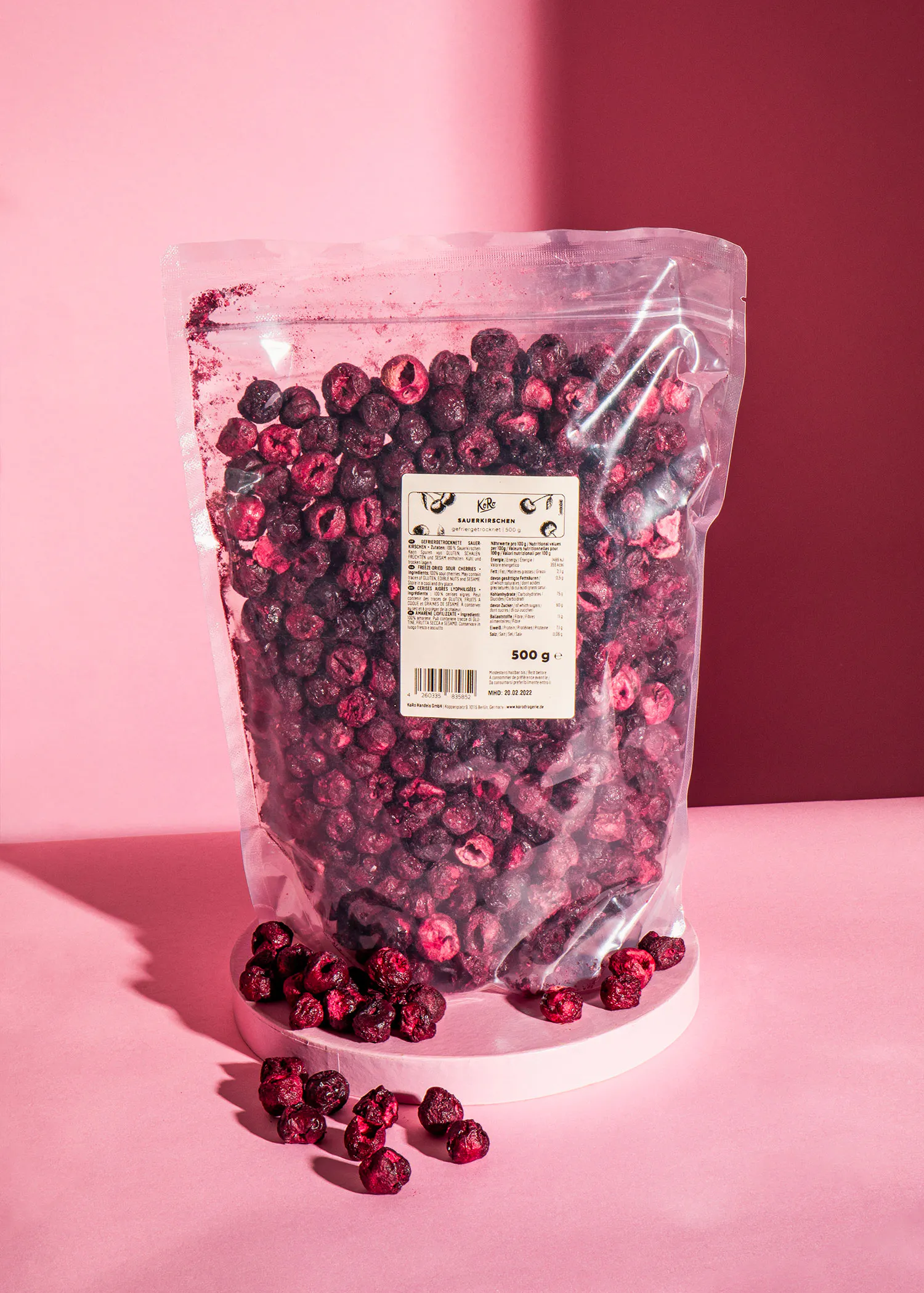 a bag of dried cranberries sits on a pink table