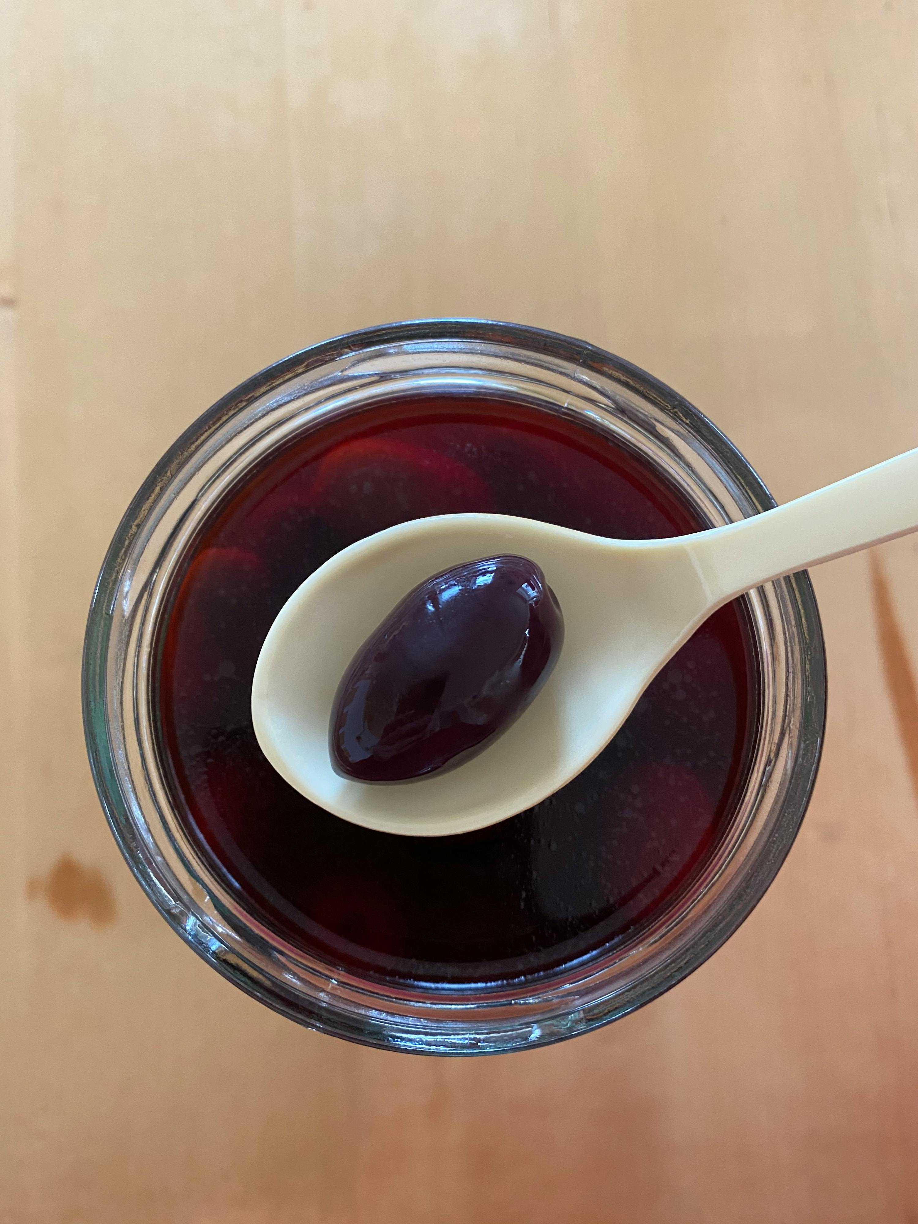 ein Glas mit einem Löffel darin und einer Olive darin