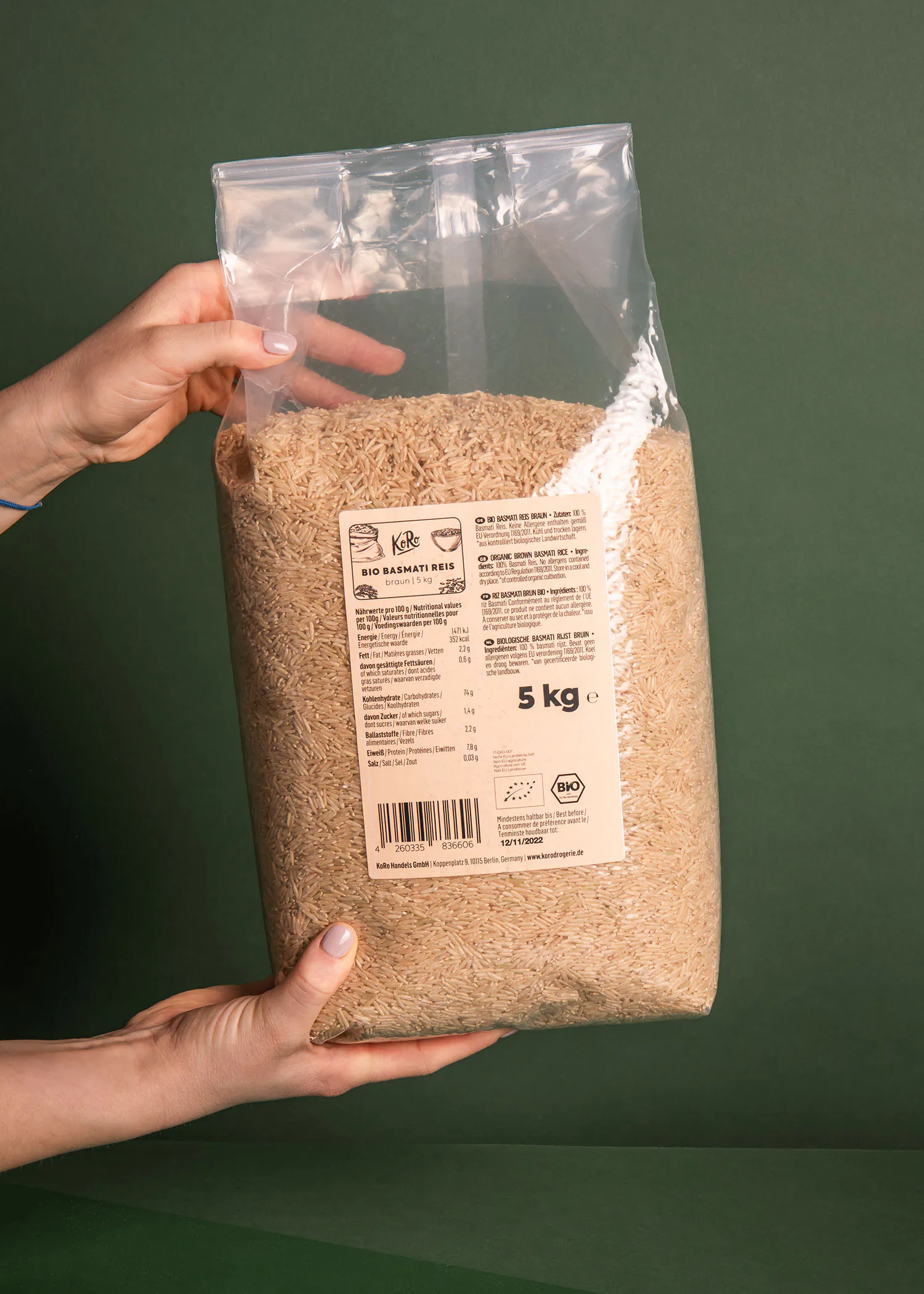 eine Person hält einen Plastiksack mit 5 kg Reis in ihren Händen