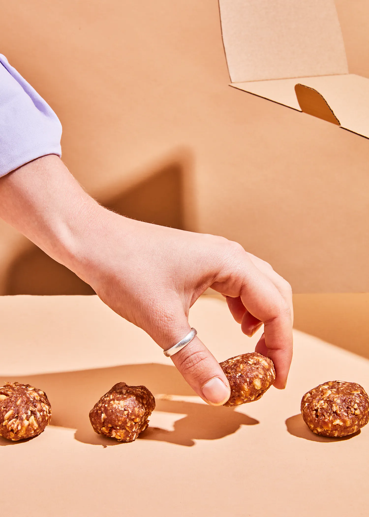 une personne avec un anneau sur le doigt touche un biscuit