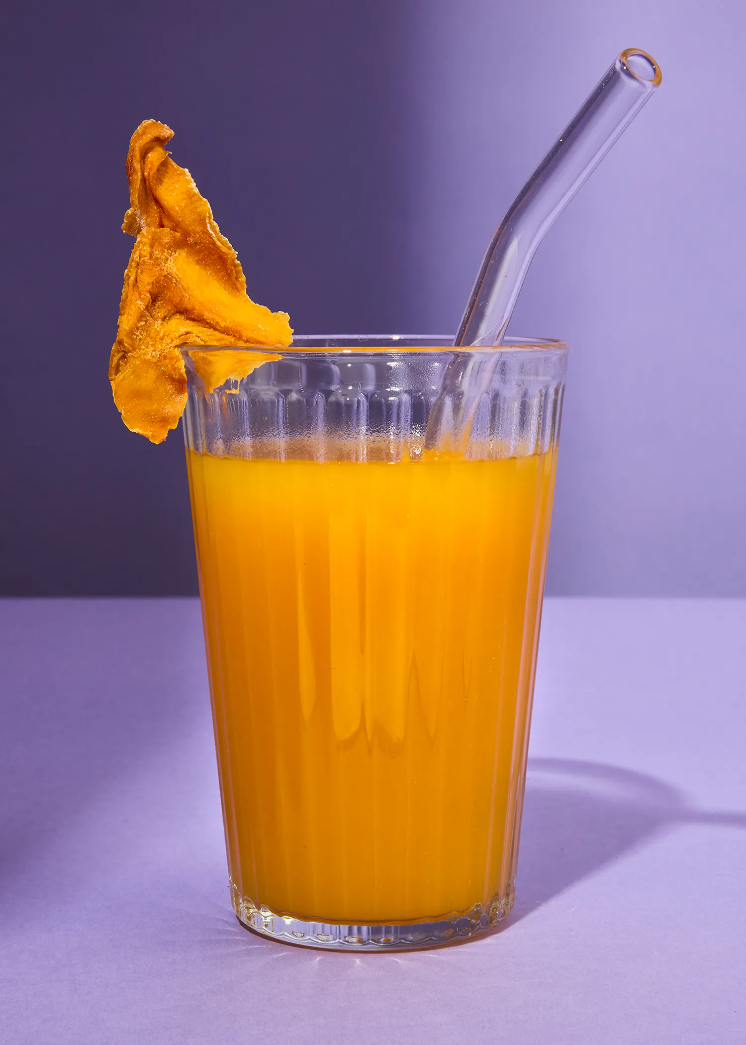 ein Glas Orangensaft mit einem Strohhalm