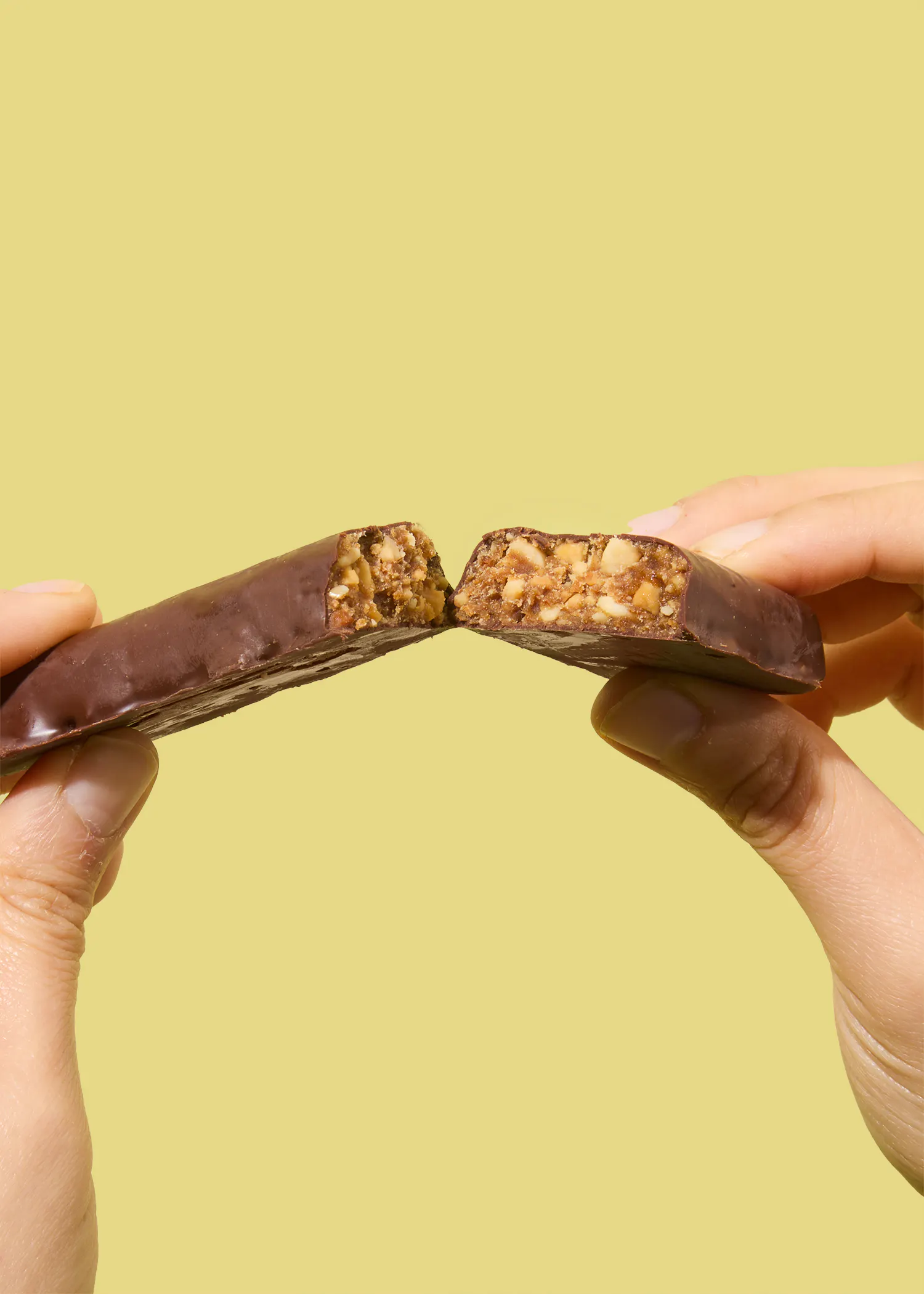 une personne tient une barre de chocolat en deux