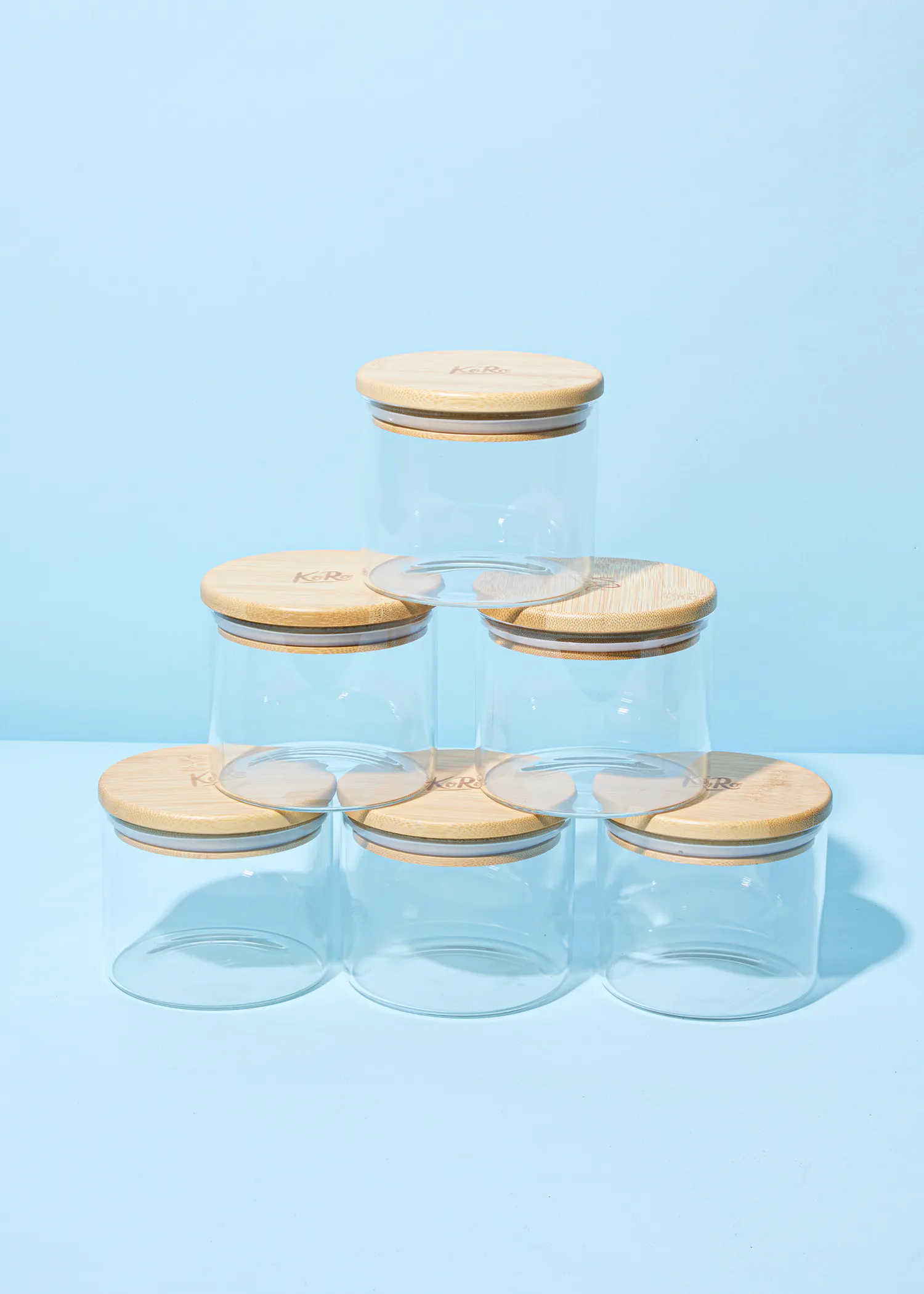 eine Reihe von Gläsern mit Holzdeckeln auf einem Tisch