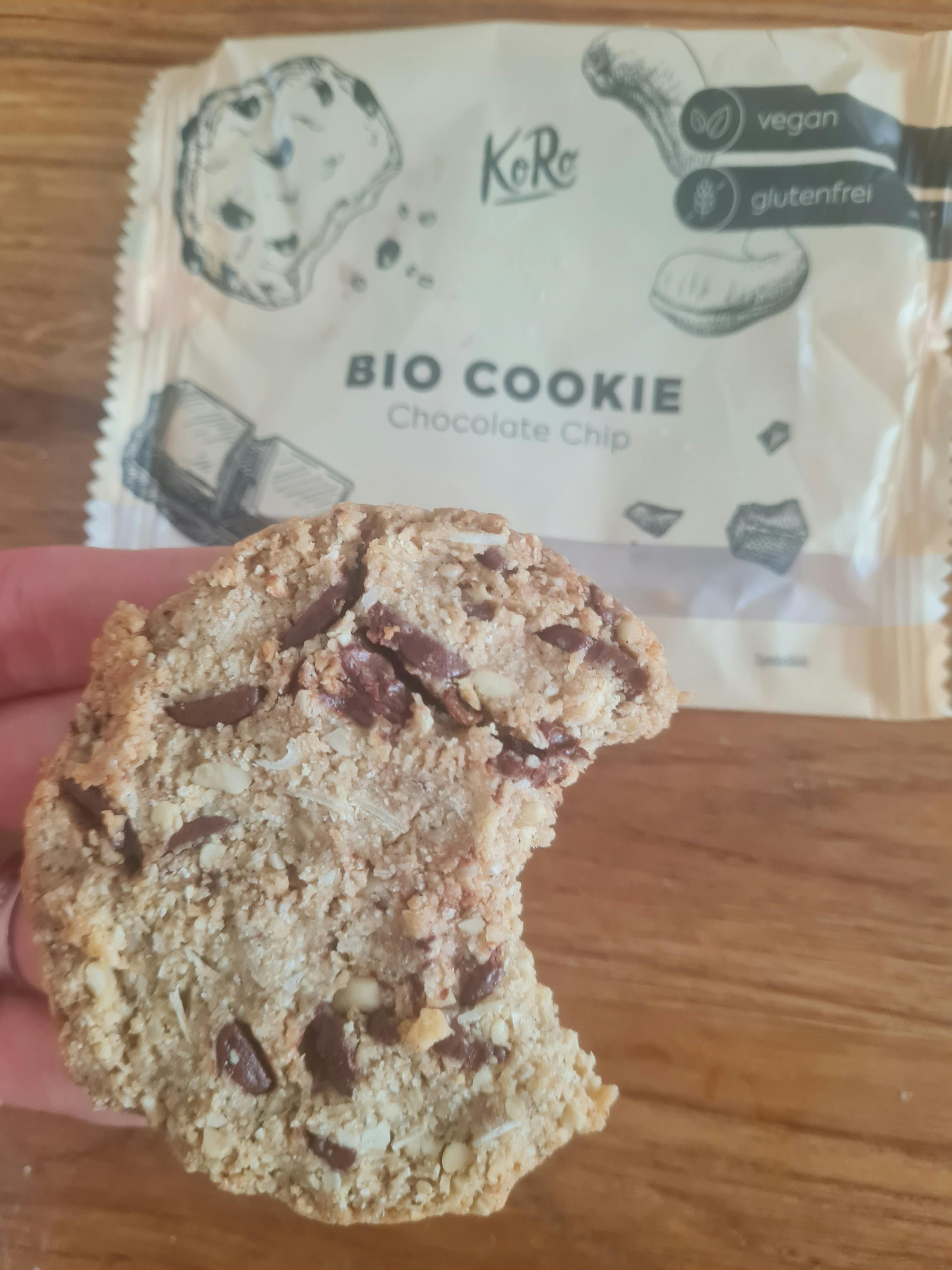 Eine Person hält ein Bio-Keks mit Schokoladenchips in der Hand
