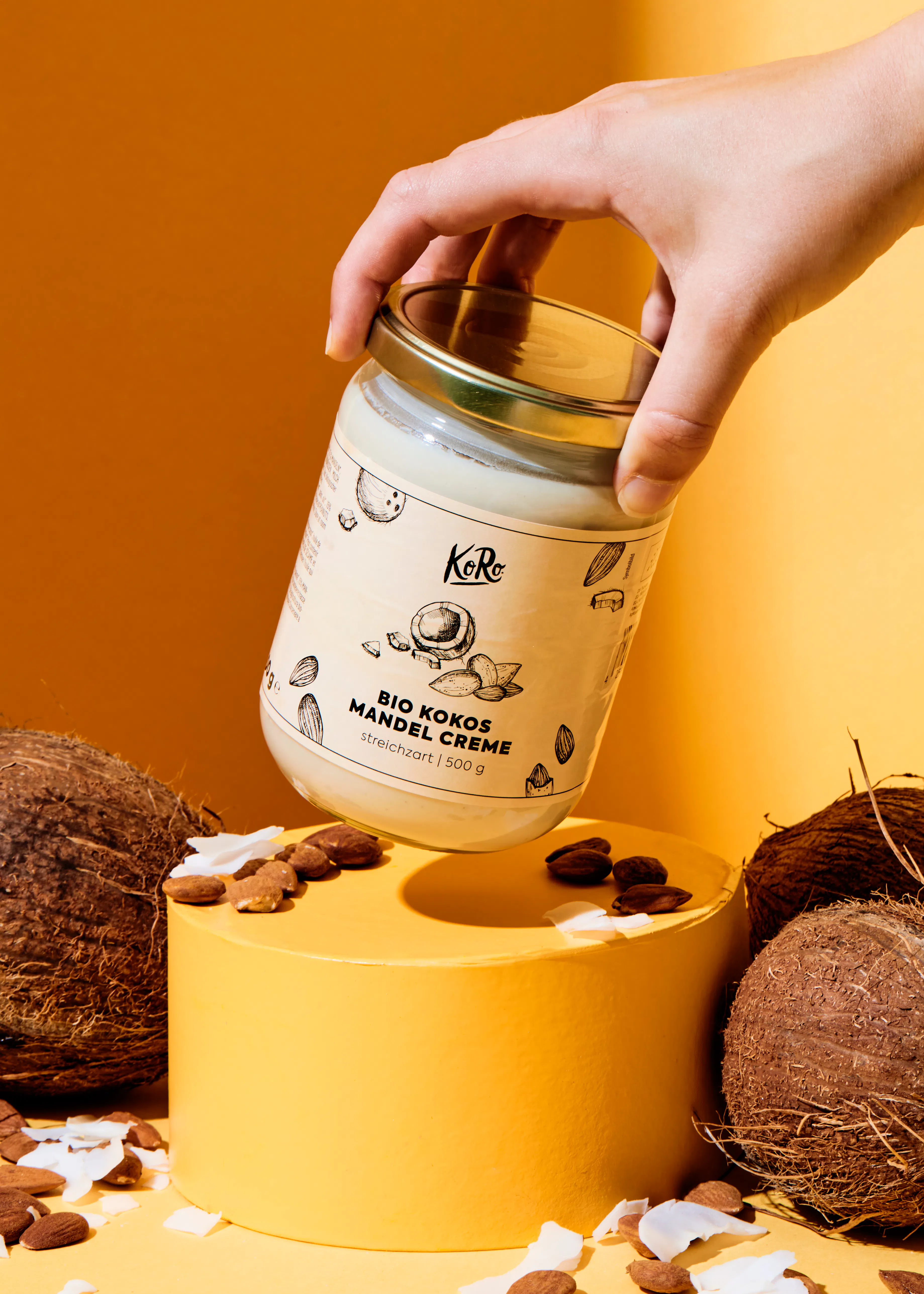 une personne tient un pot de crème de coco bio