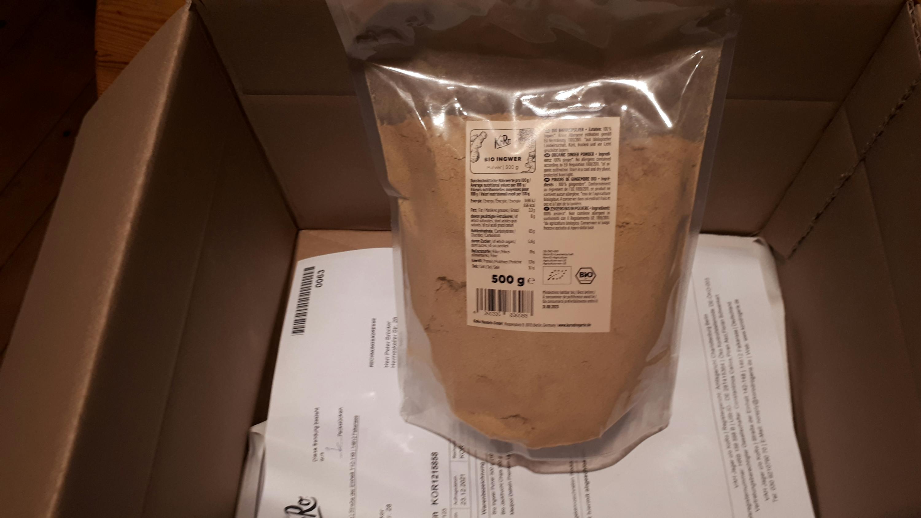 ein Plastikbeutel mit braunem Pulver liegt in einer Schachtel