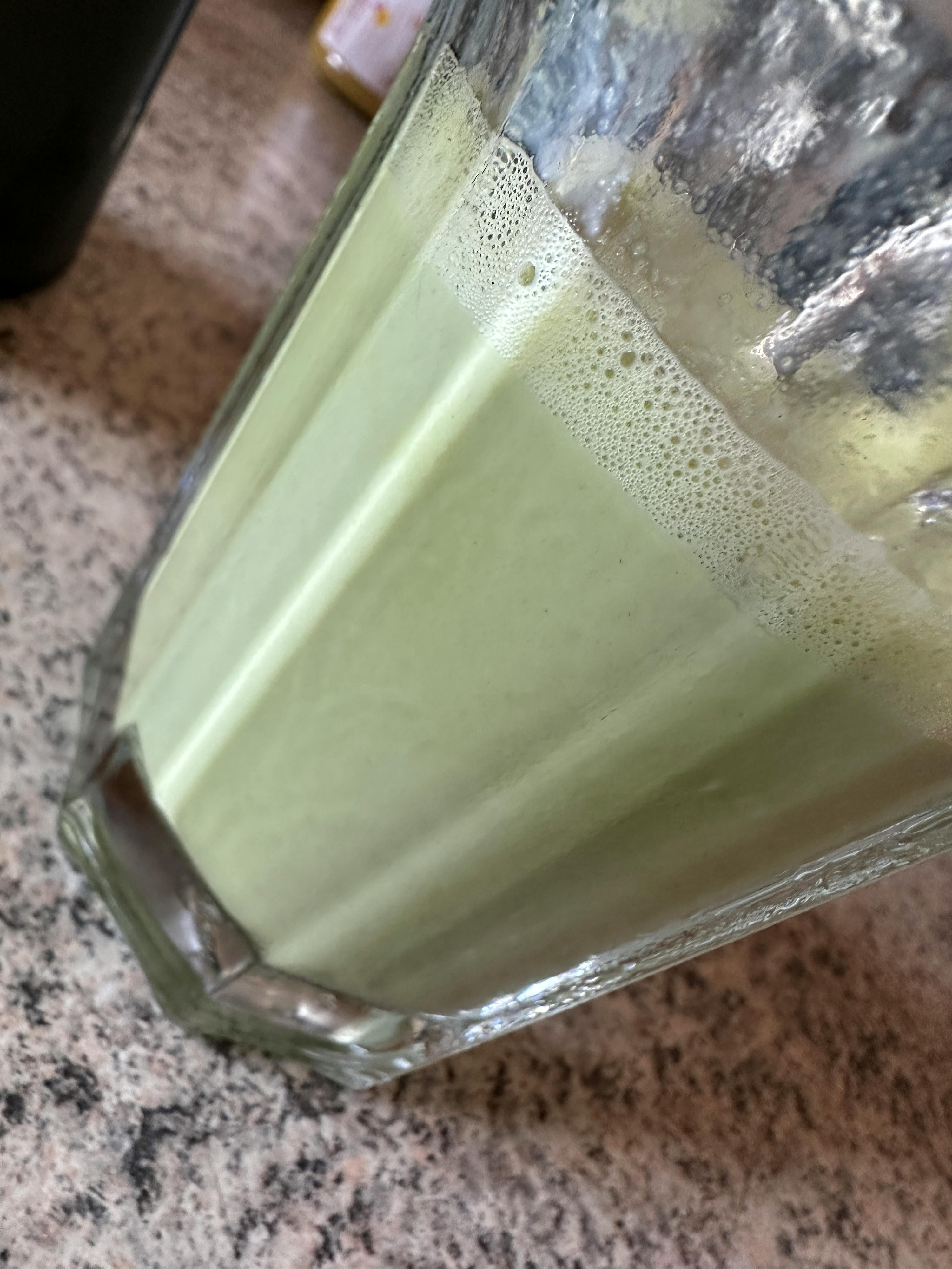 a close up of a green drink in a glass