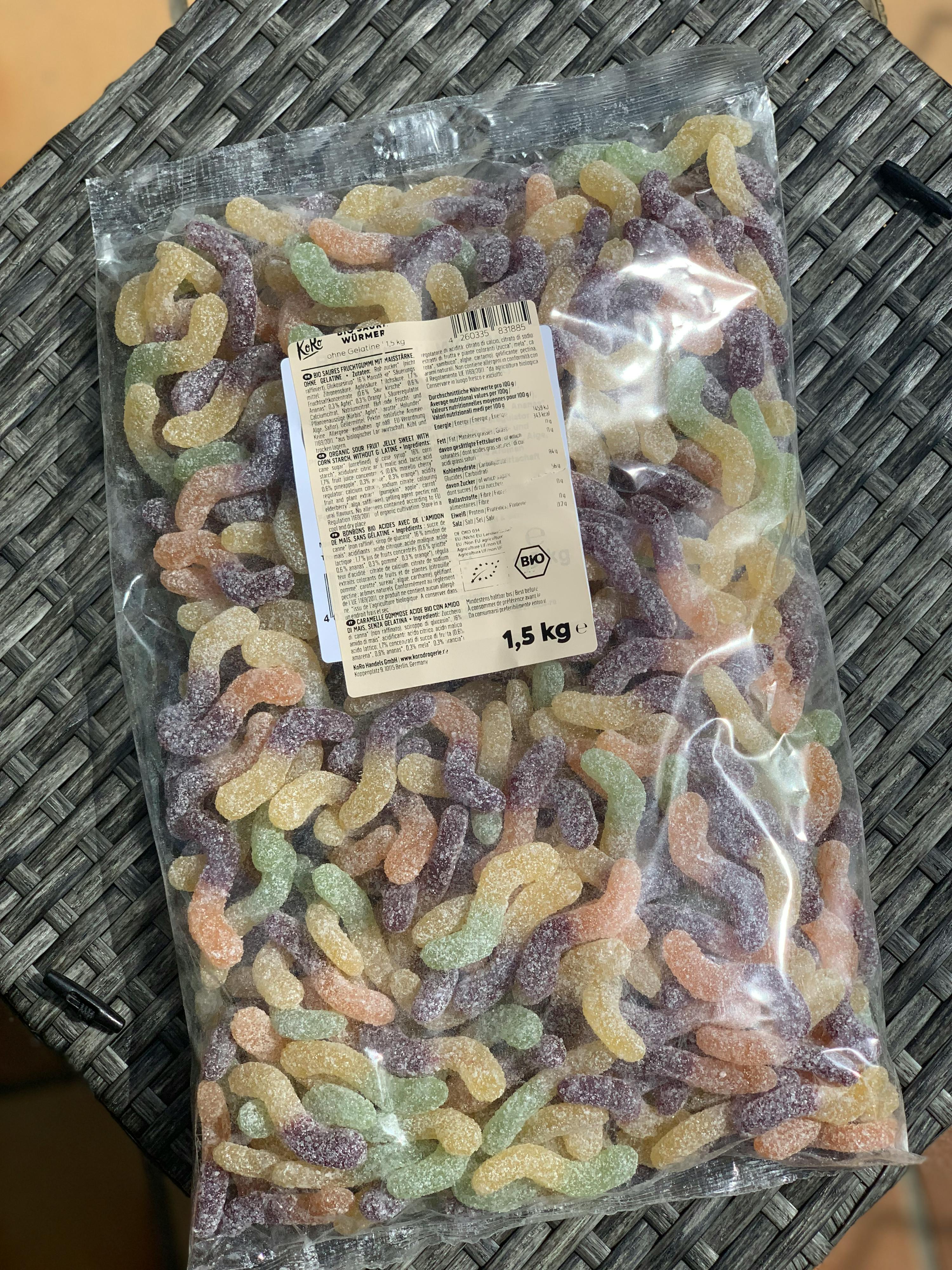un sacchetto di caramelle a forma di lumaca è seduto su un tavolo di vimini