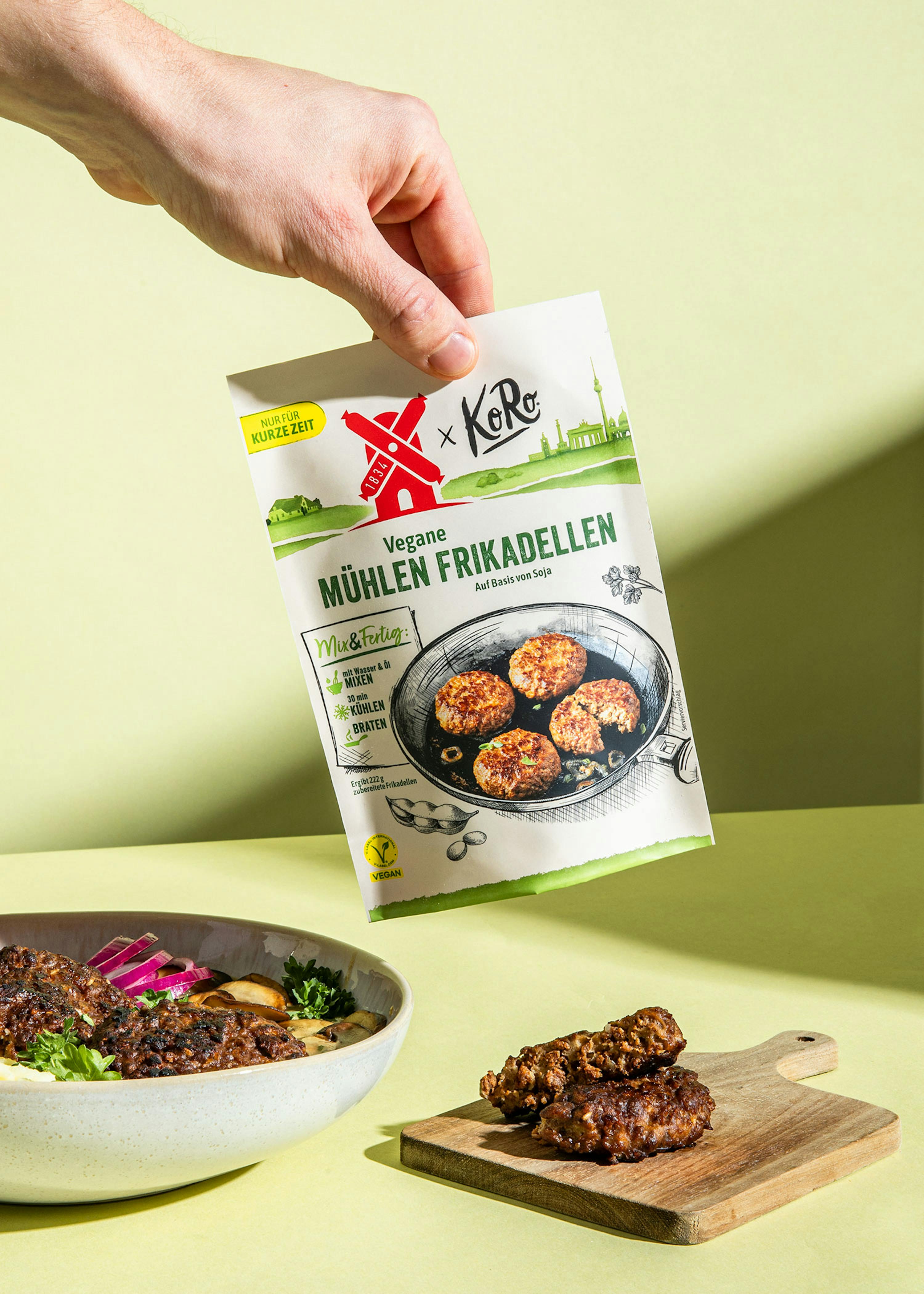 Eine Person hält eine Tüte mit veganen Mühlenfrikadellen in der Hand