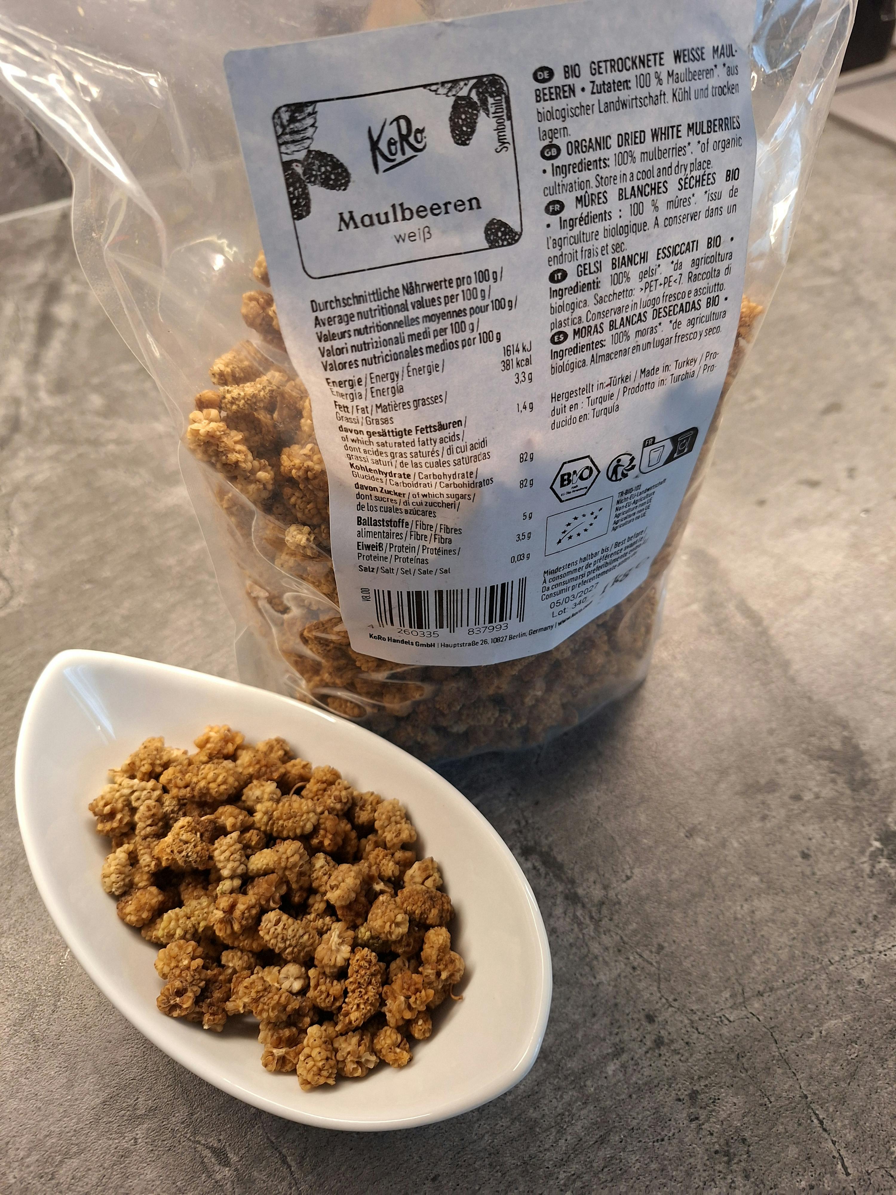 un sacchetto di frutta secca è seduto accanto a un piatto di frutta secca