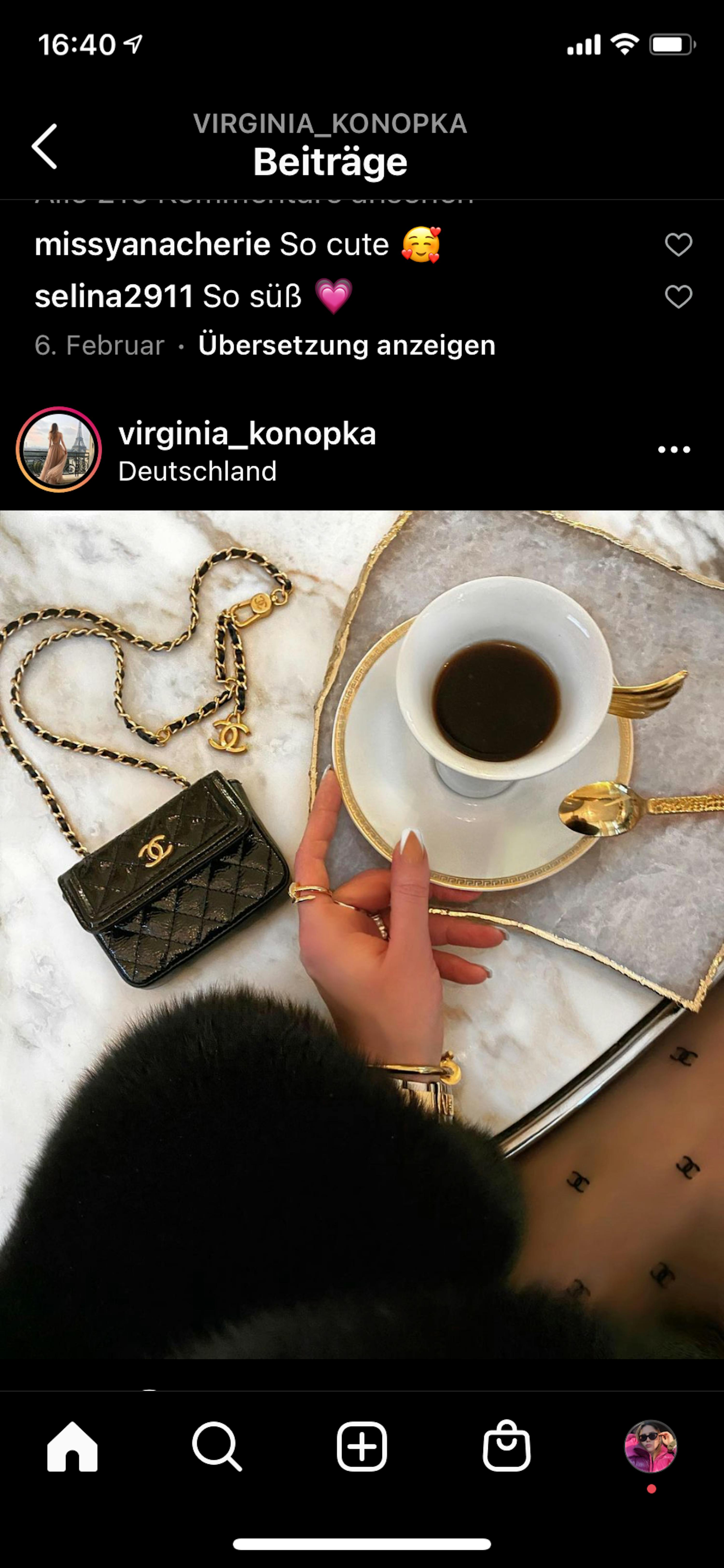 una donna tiene in mano una tazza di caffè accanto a una borsa chanel