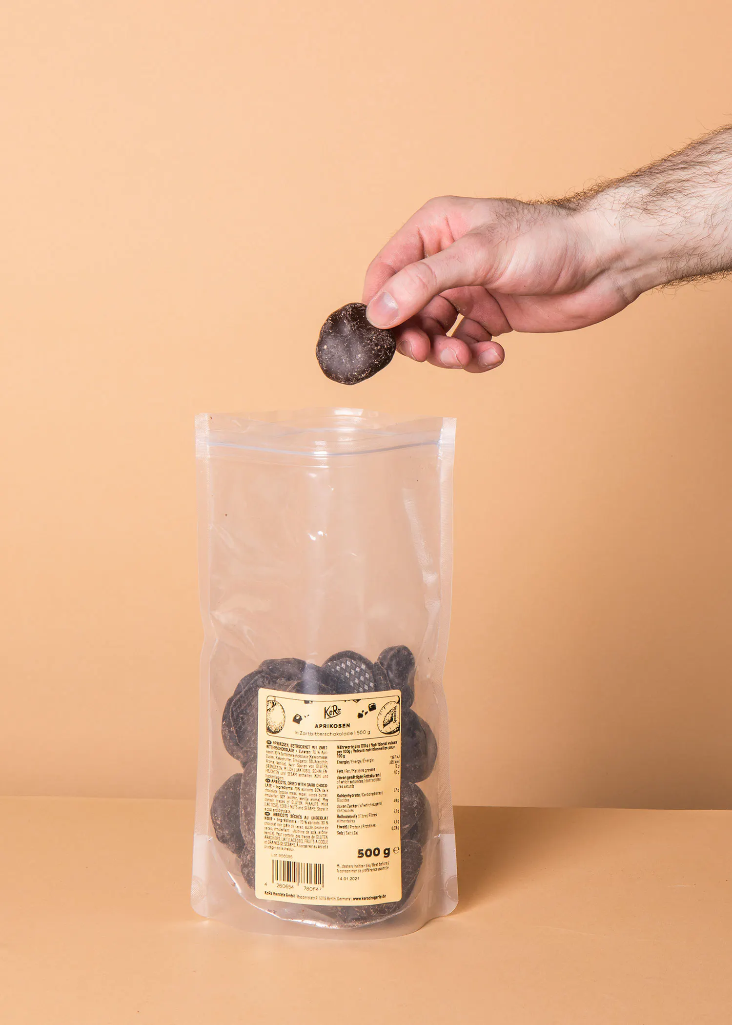 eine Person greift nach einem Stück Schokolade aus einer Plastiktüte