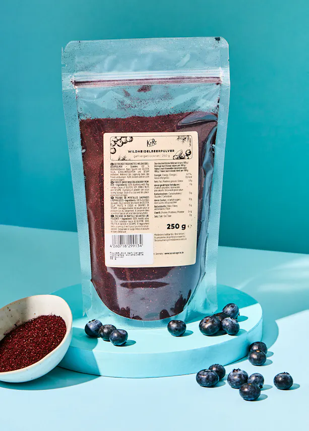 a bag of powdered blueberries is sitting on a blue surface