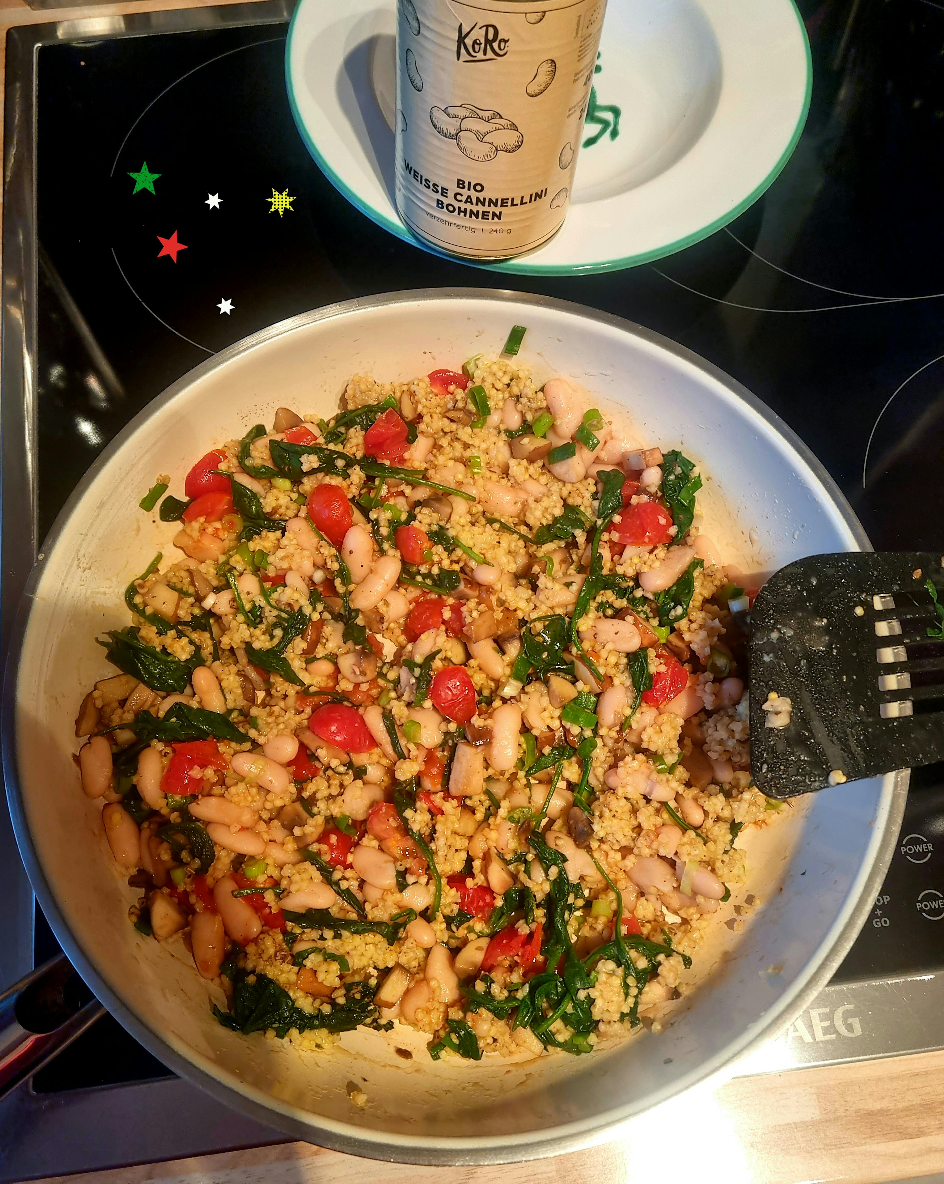 une poêle remplie de nourriture sur une cuisinière avec une bouteille de graines de cannelle bio à côté