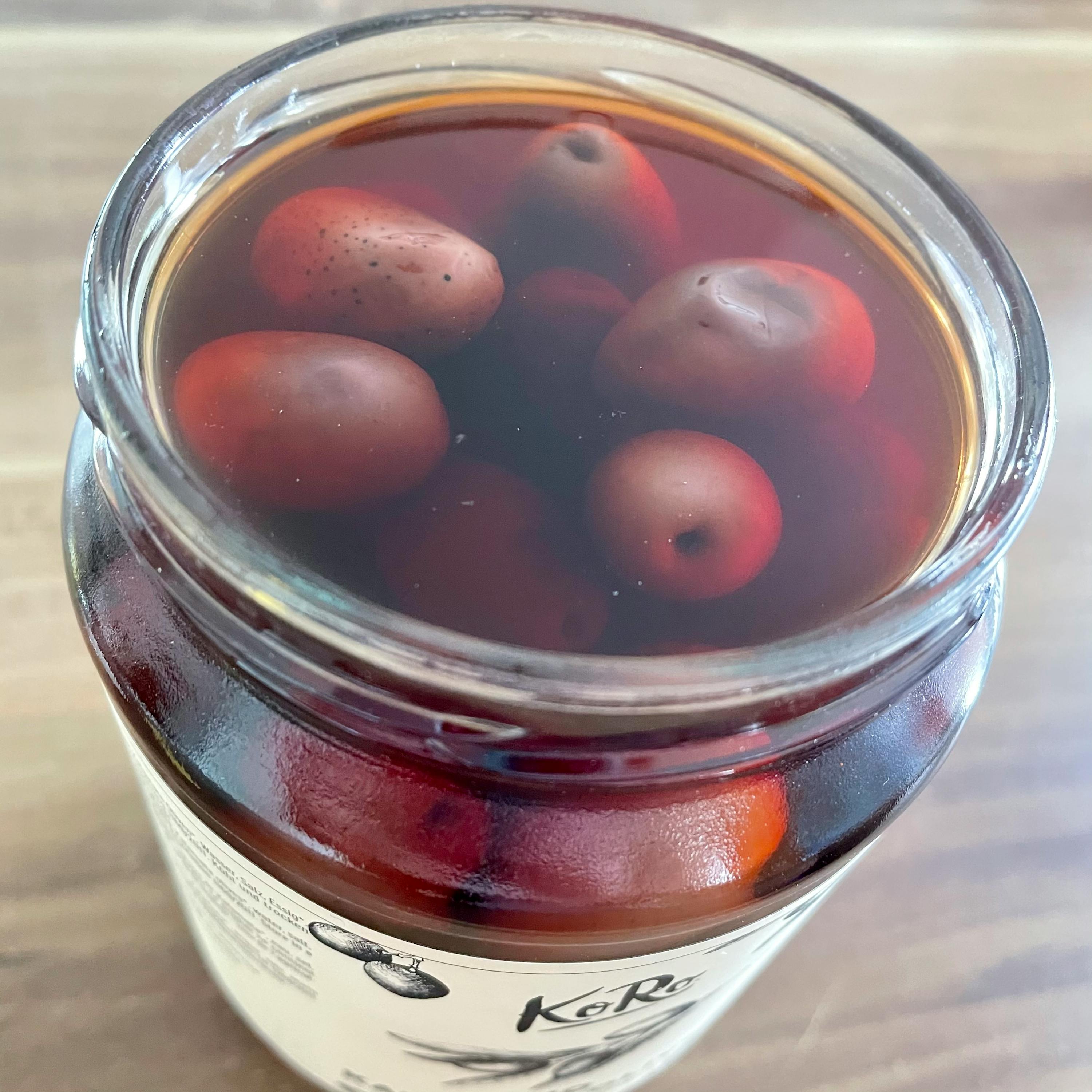 ein Glas mit roten Tomaten in einem Glas mit der Aufschrift kor