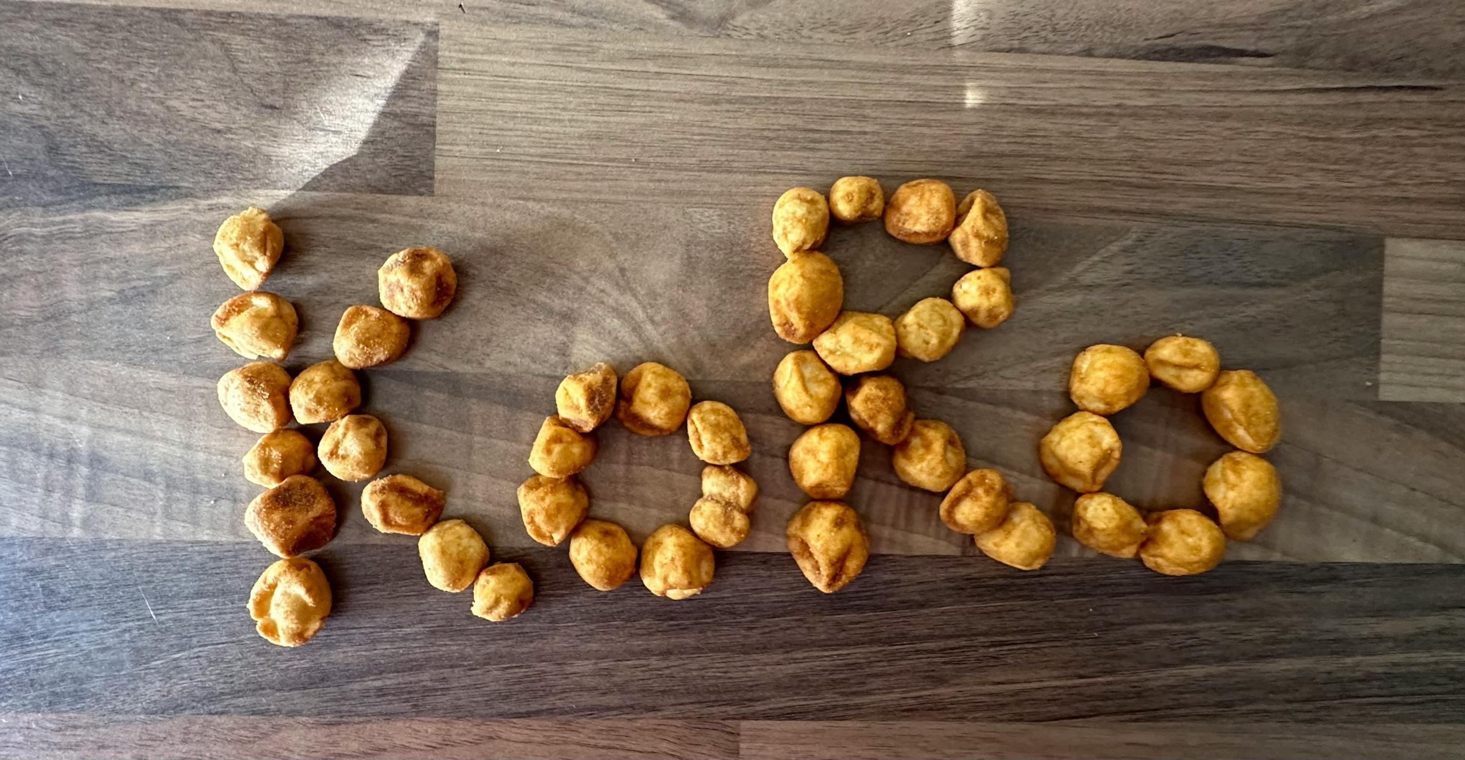 les mots love sont écrits avec des arachides sur une table en bois
