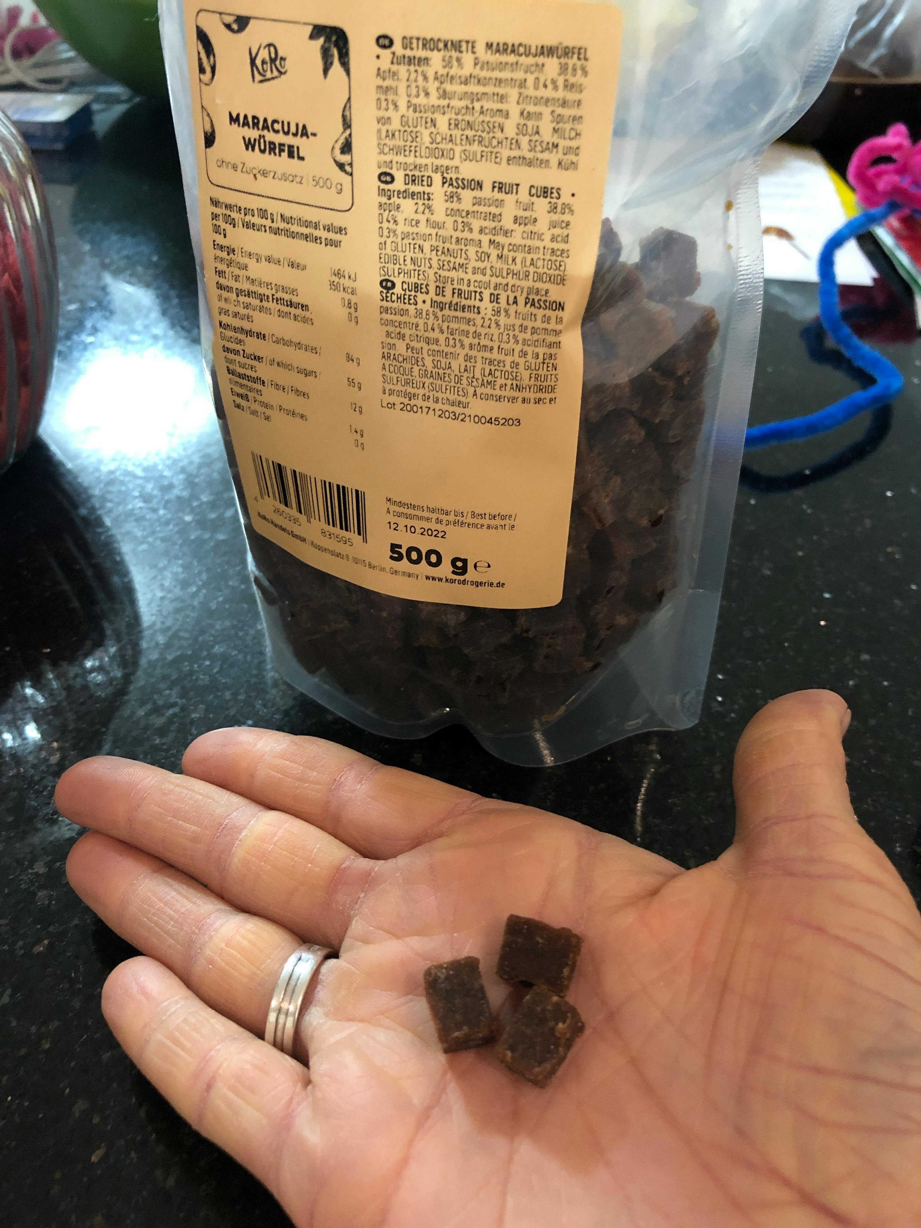 une personne tient un sac de raisins secs à la main