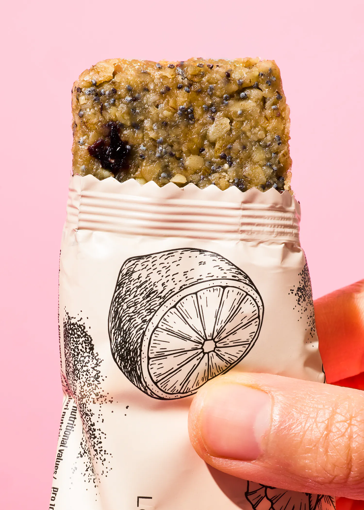 une personne tient une barre de céréales avec une tranche d' orange sur le côté