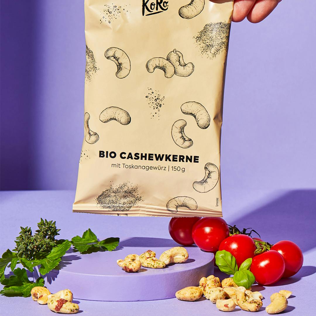 Eine Person hält eine Tüte Bio Cashewkerne mit Toskana Gewürz