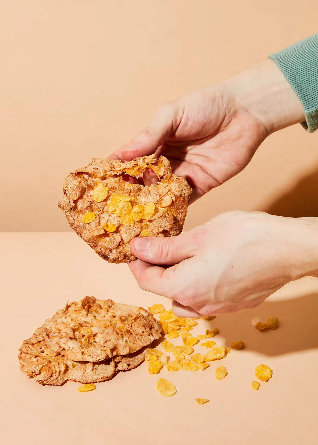 une personne tient un biscuit rempli de flocons de maïs dans ses mains