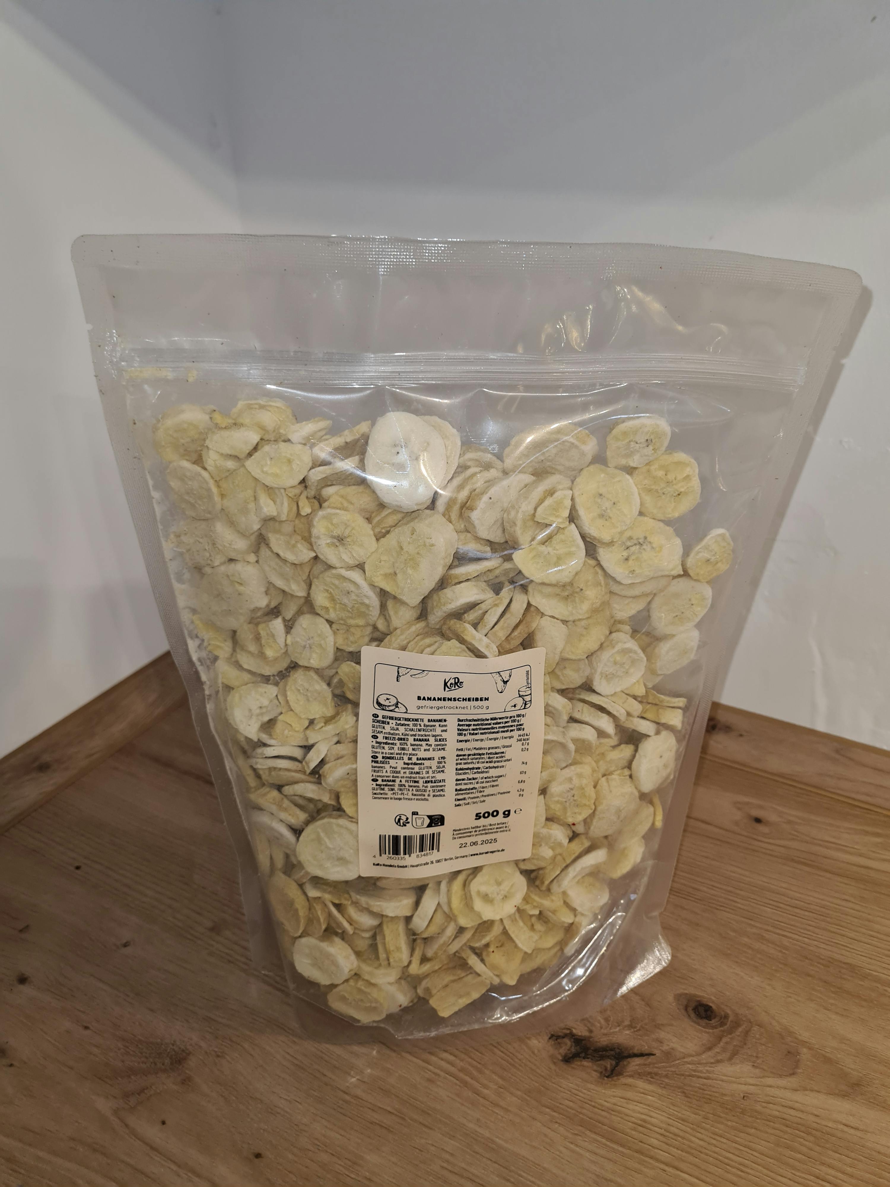 a bag of dried banana slices is sitting on a wooden table