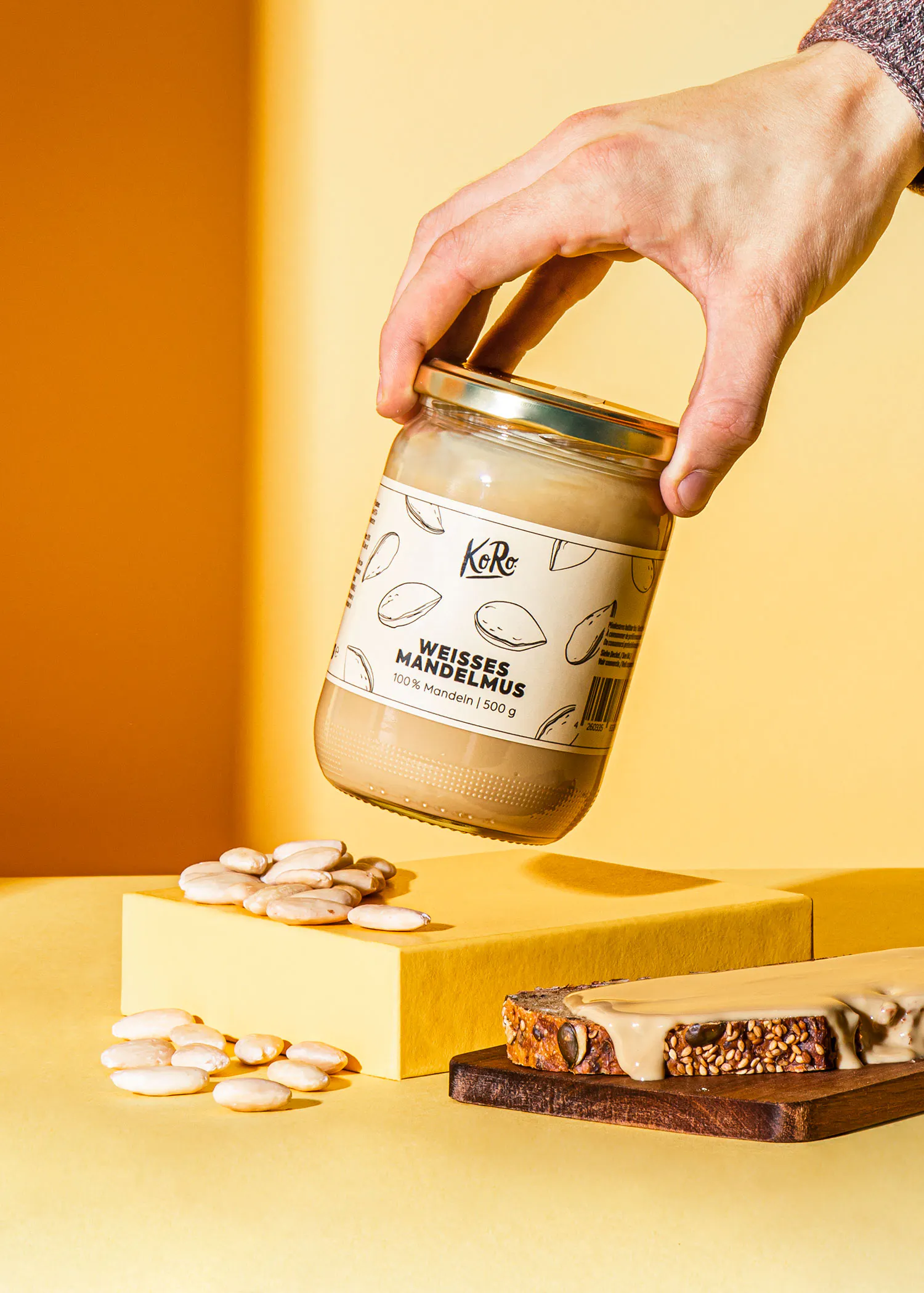 eine Person hält ein Glas weißes Mandelbutter