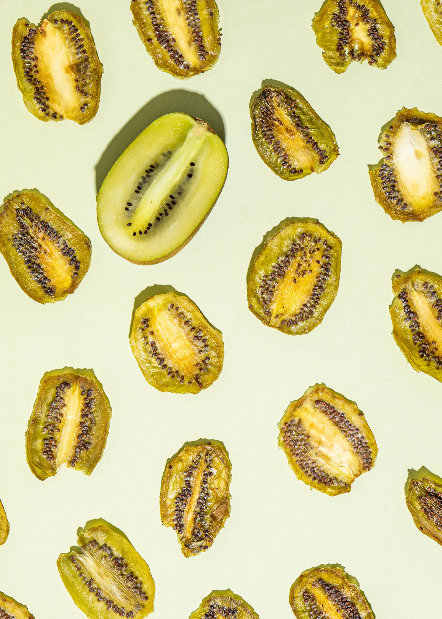 a pattern of kiwi slices on a green background