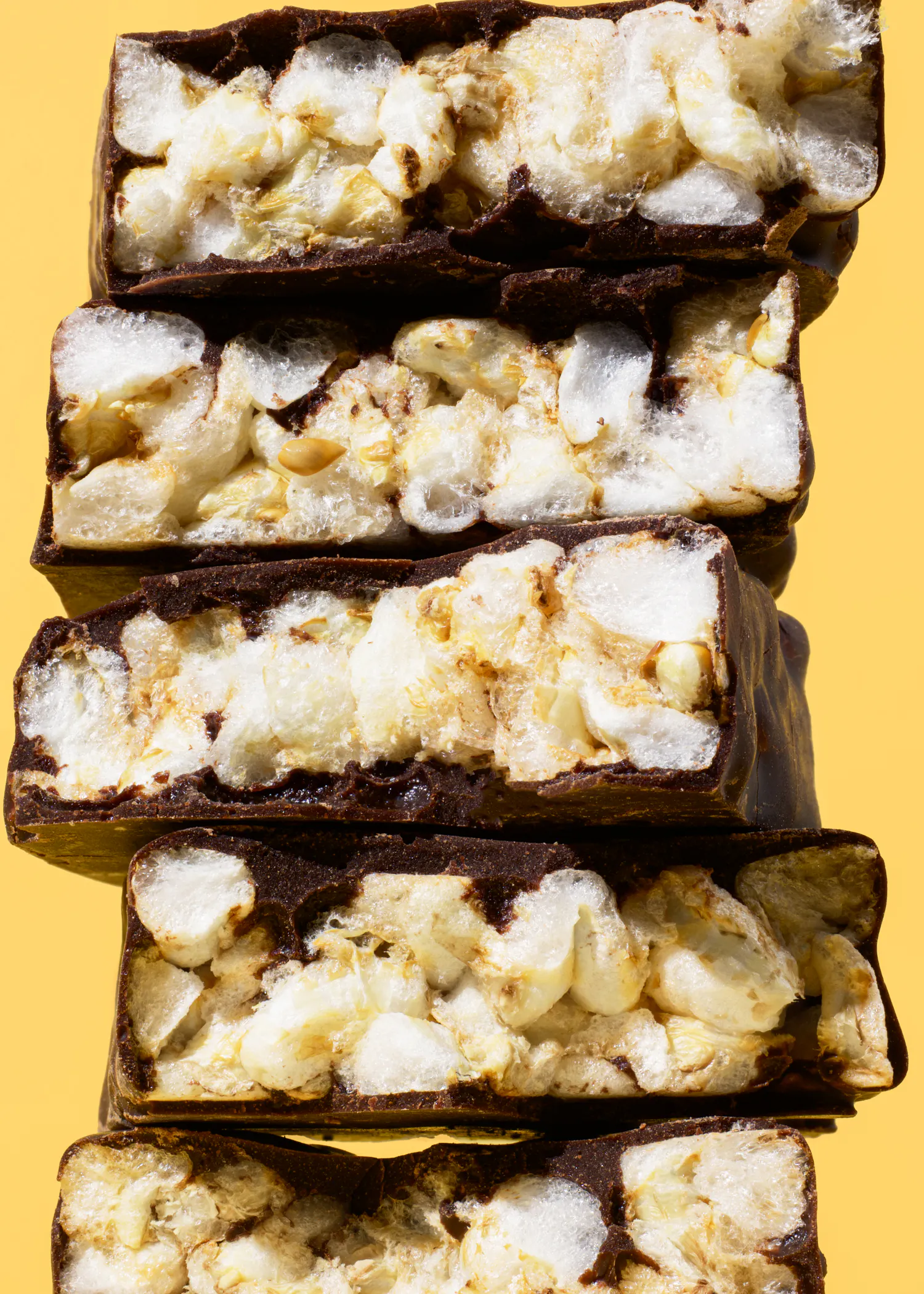 trois barres de chocolat empilées les unes sur les autres sur un fond jaune