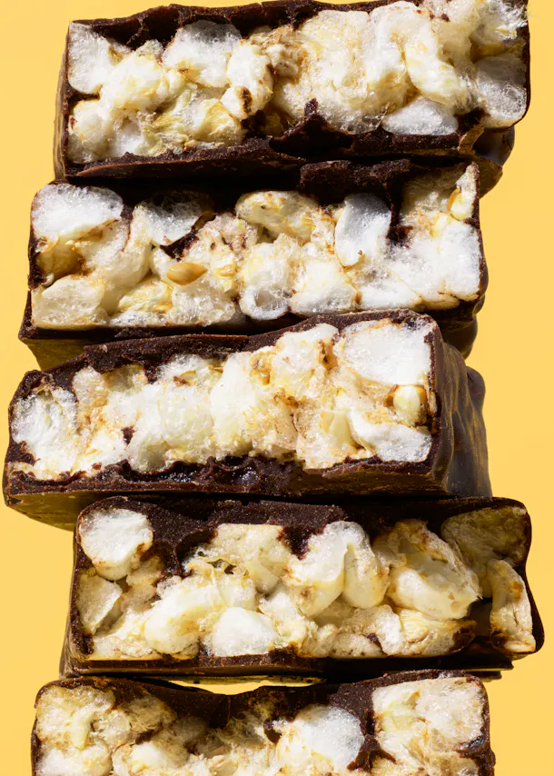 trois barres de chocolat empilées les unes sur les autres sur un fond jaune