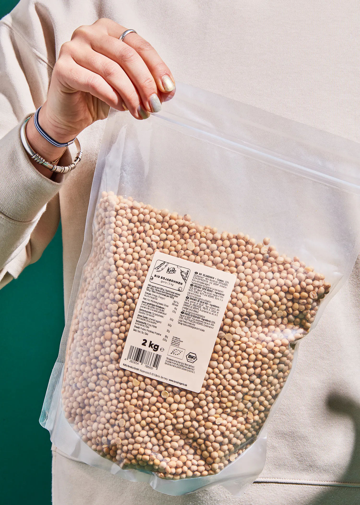 eine Person hält einen Plastikbeutel mit sojabohnen in ihren Händen