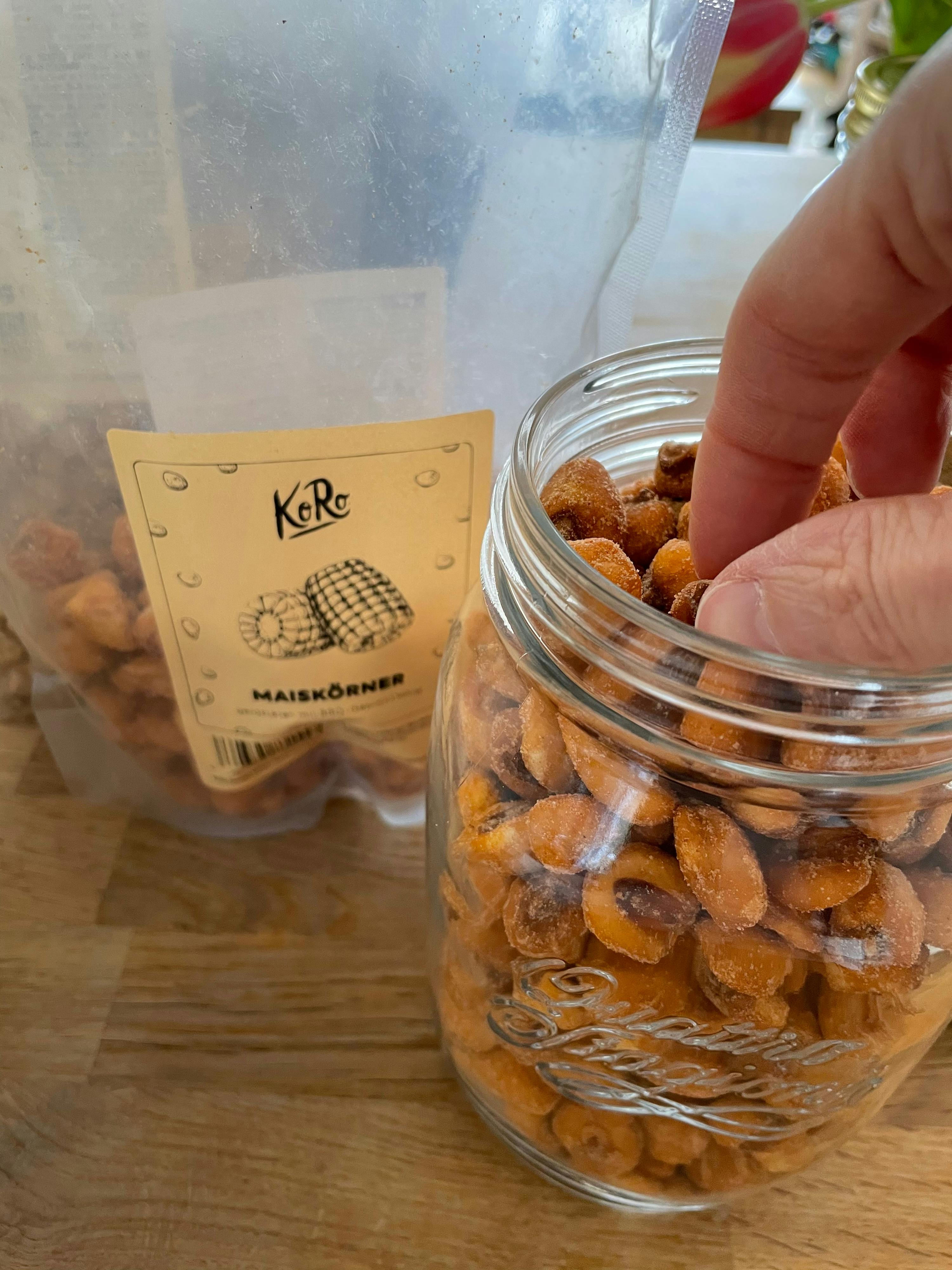 una persona raggiunge un barattolo di maiskorner